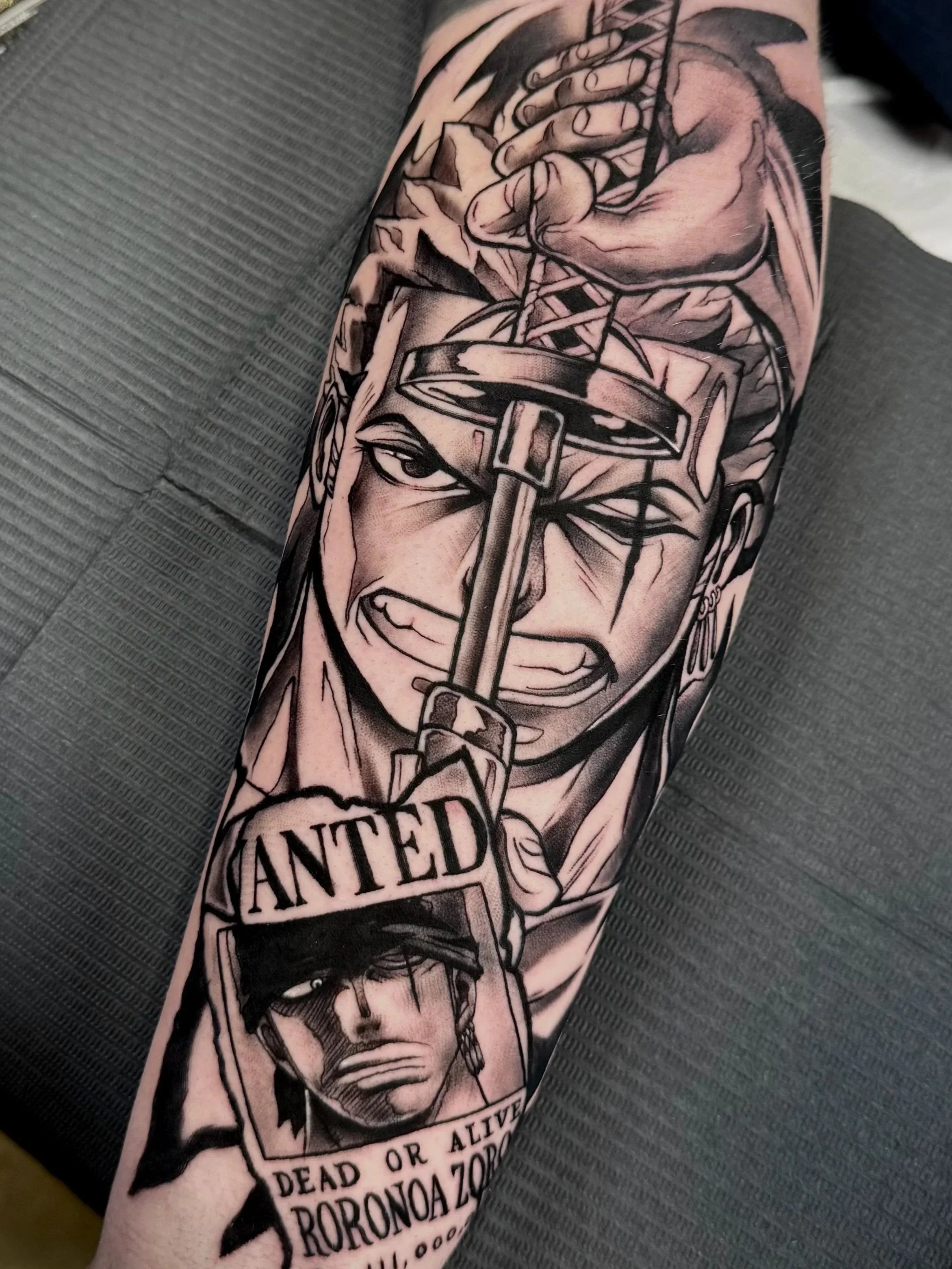 Anime Tattoo von Roronoa Zoro aus One Piece in Black & Grey auf dem Unterarm