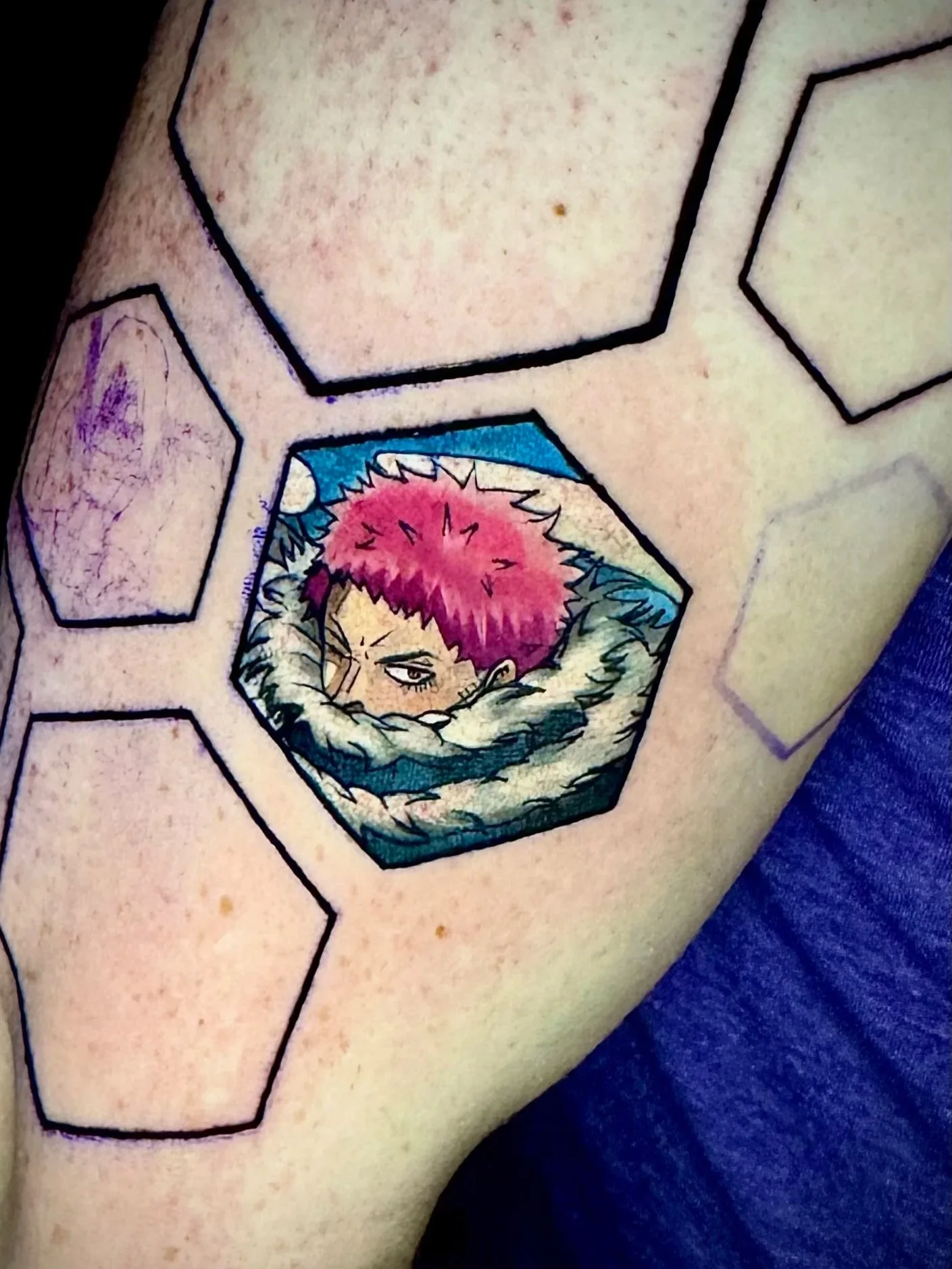Tattoo eines Comics, das eine Person mit pinkem Haar zeigt, die sich die Hände vor das Gesicht hält.