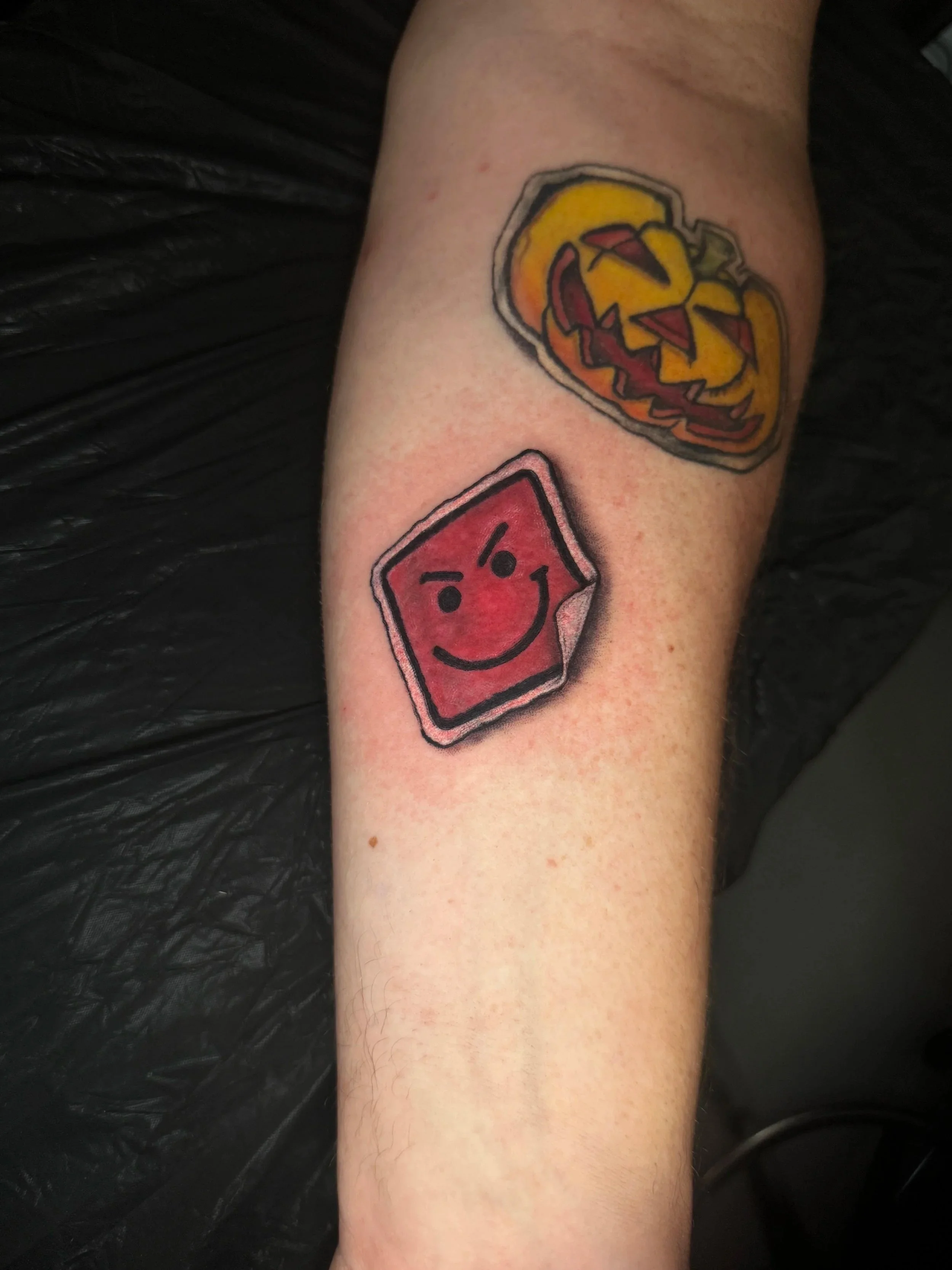 Tattoo eines lächelnden Gesichts auf dem Unterarm.