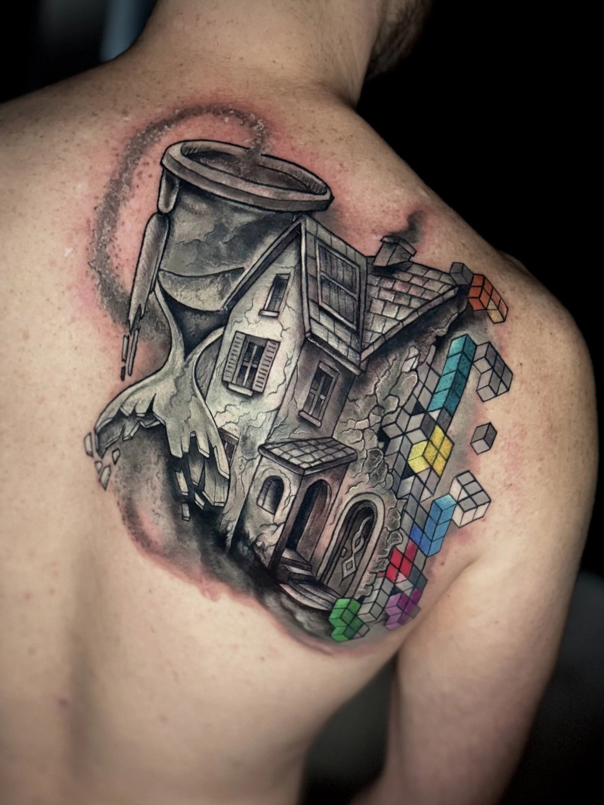 Tattoo eines Hauses mit Bäumen und Rahmengittern auf der Schulter einer Person