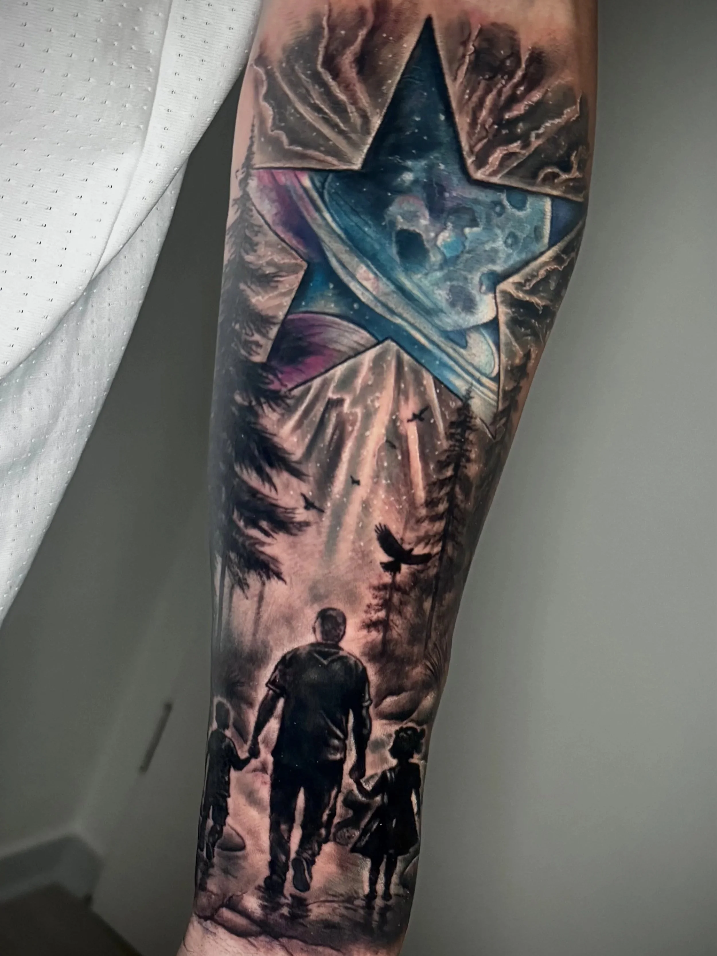 Tattoo eines Weltraum-Sternenhimmels mit einem Astronauten im Vordergrund, Vögeln und Landschaft im Hintergrund.