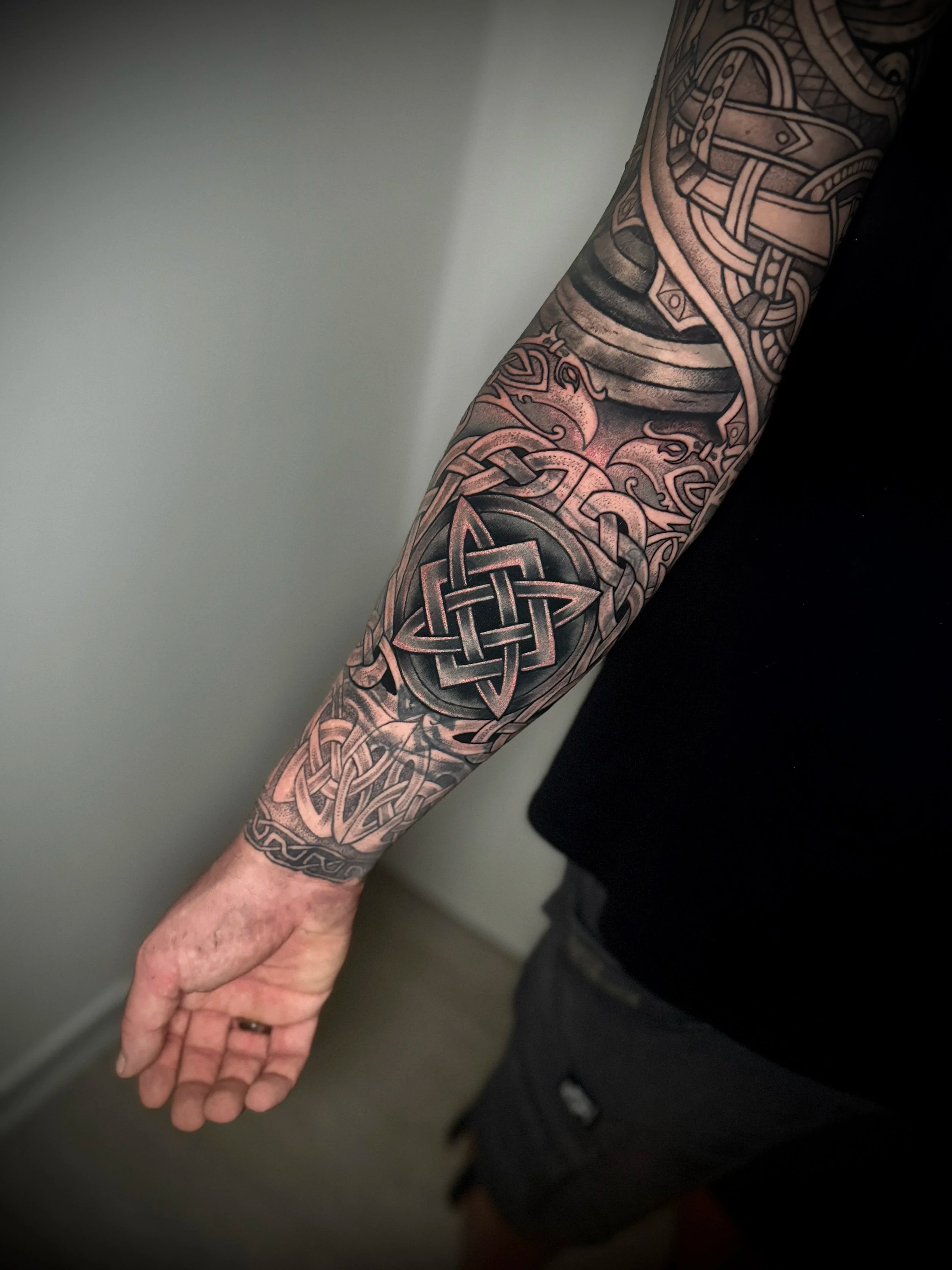 Tattooarm mit keltischem Knoten, Muster und traditionellen Designs.