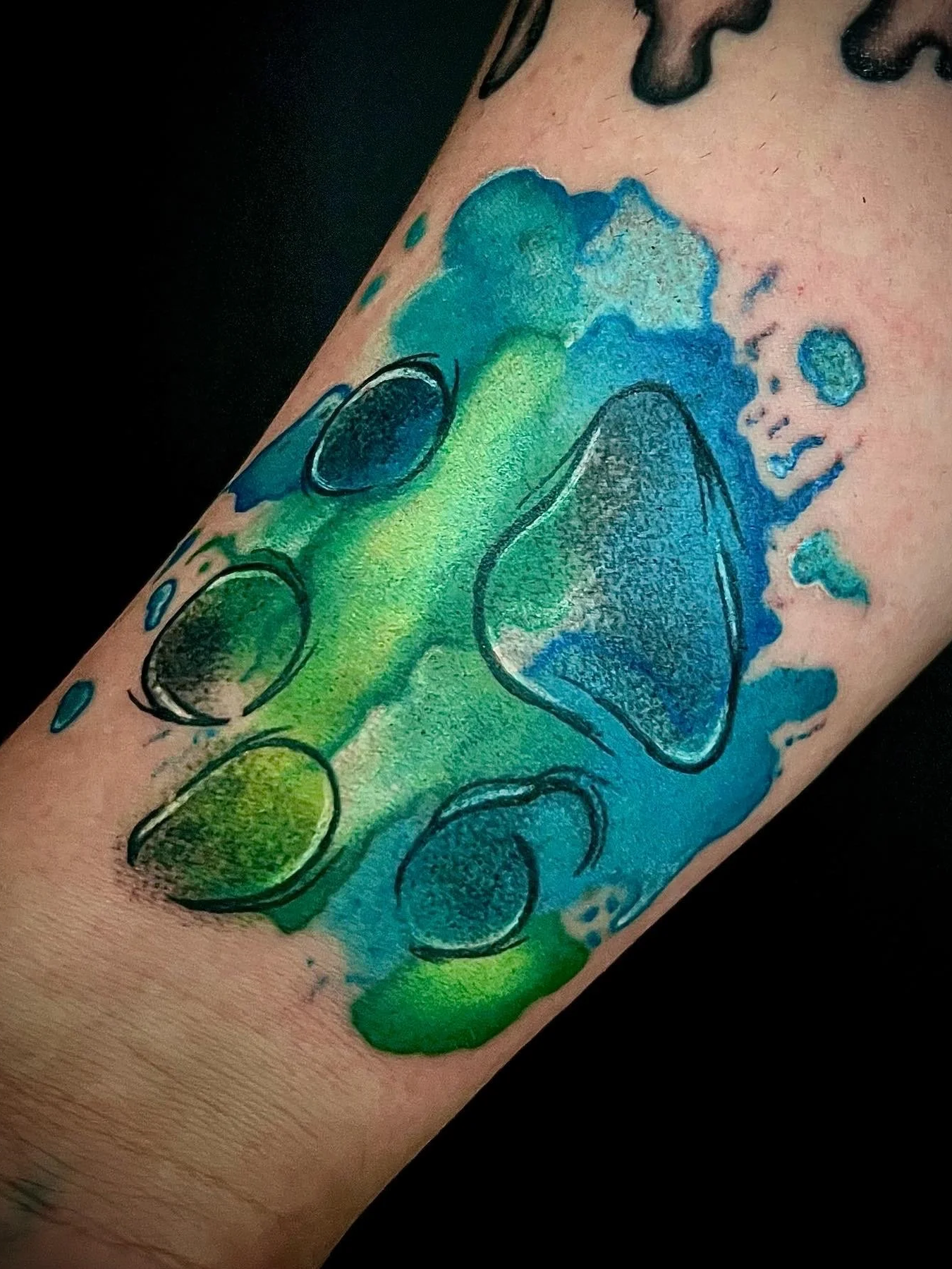 Buntes Tattoo eines Wasserfalls mit Wasser und Steinen auf einem Unterarm