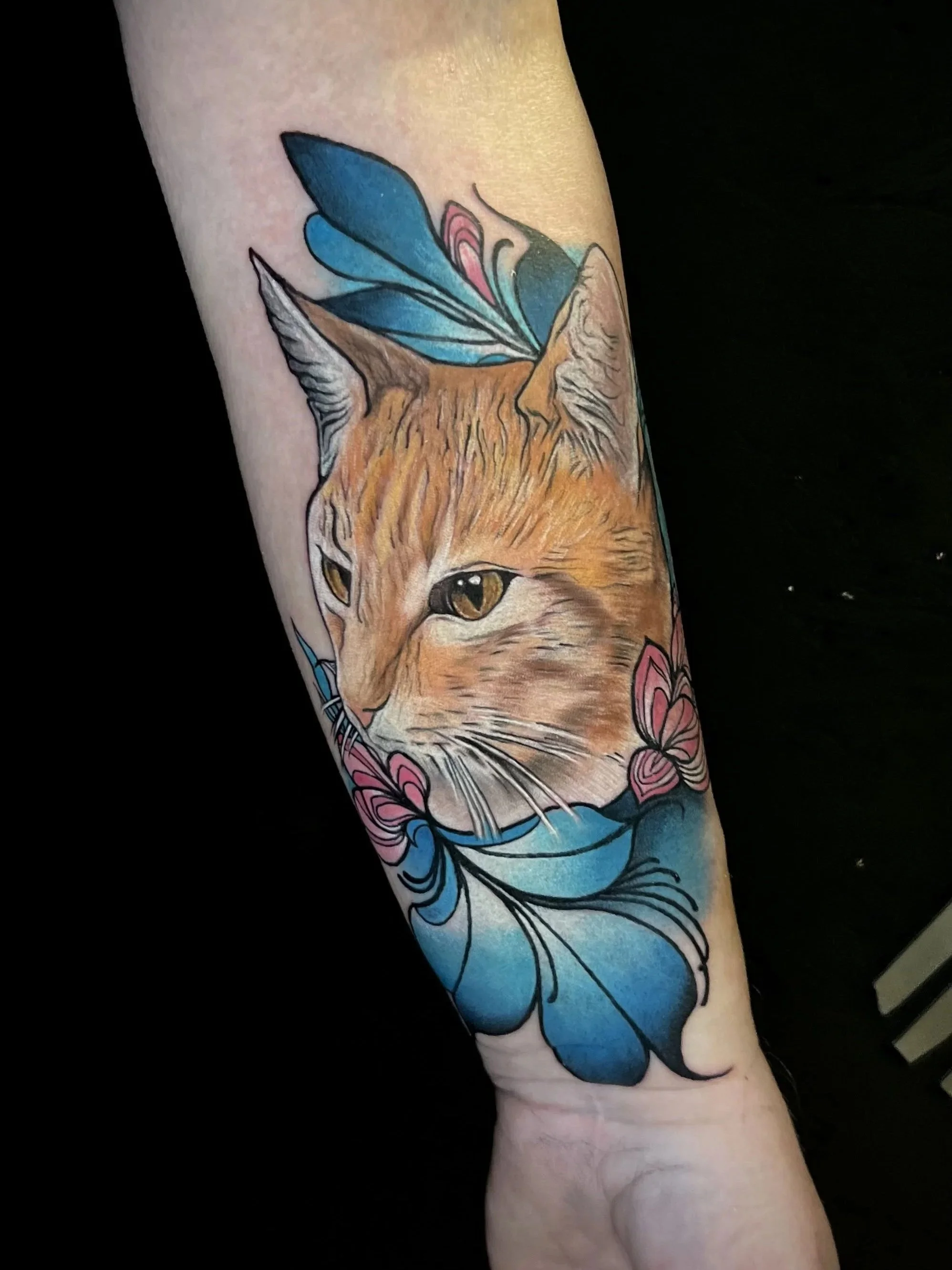Tattoo eines Fuchses mit blauen Schmetterlingsflügeln und Blumen auf dem Unterarm.