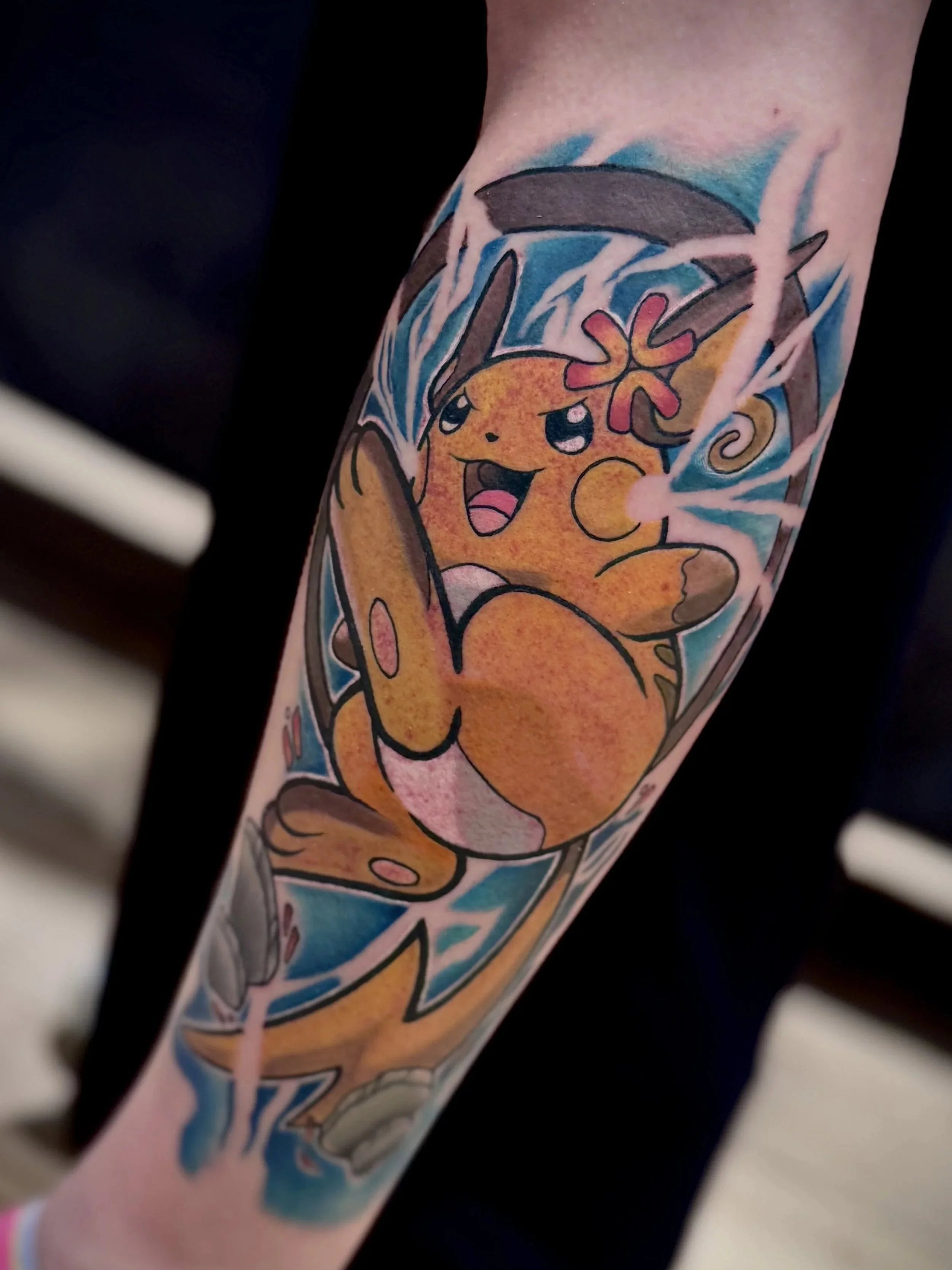 Bunte Tattoo von Pikachu mit Blitz und Pokémon-Design auf dem Unterarm