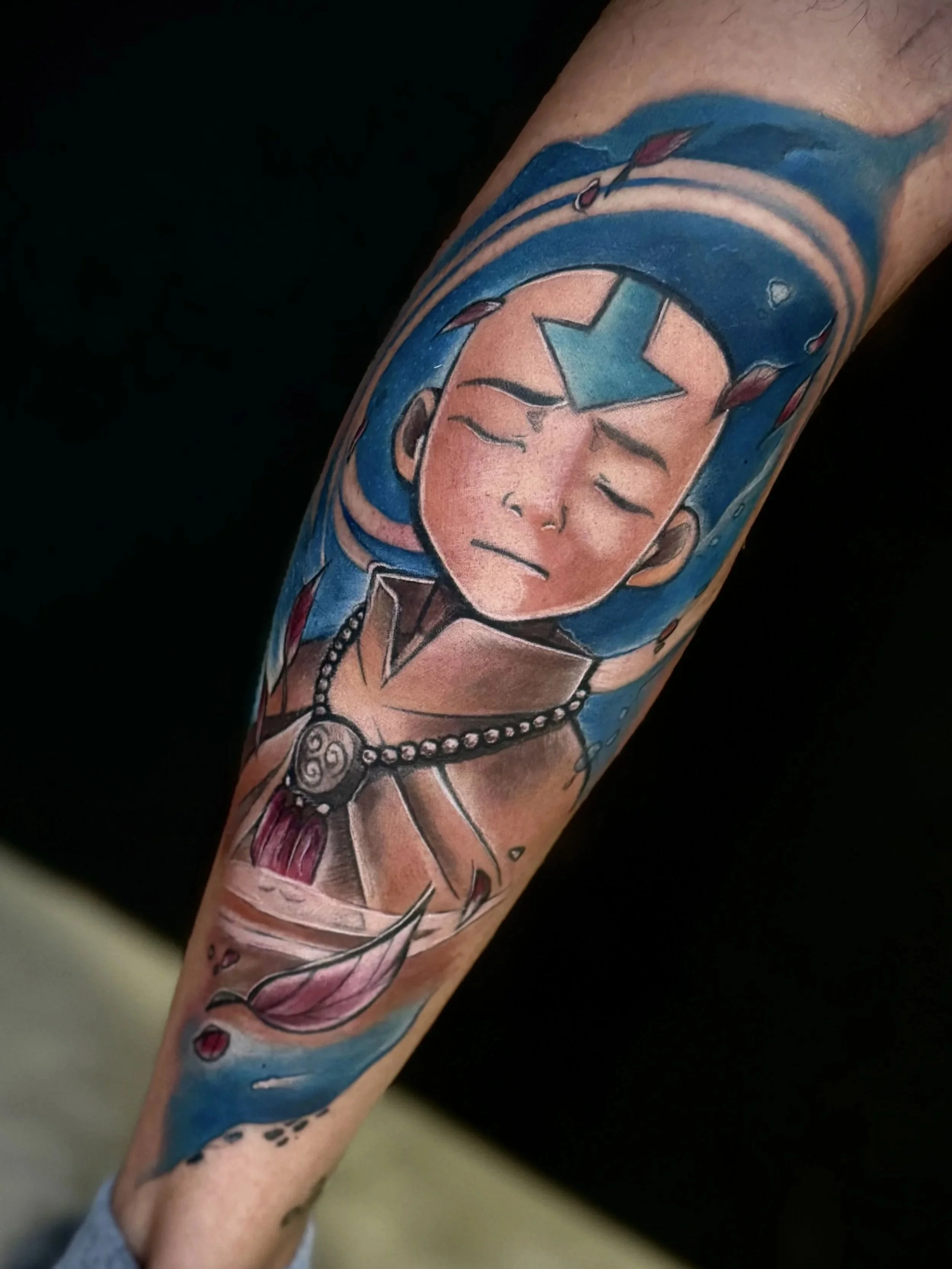 Tattoo eines Mädchengesichts mit geschlossen Augen, umgeben von Wasser und einer Blume.