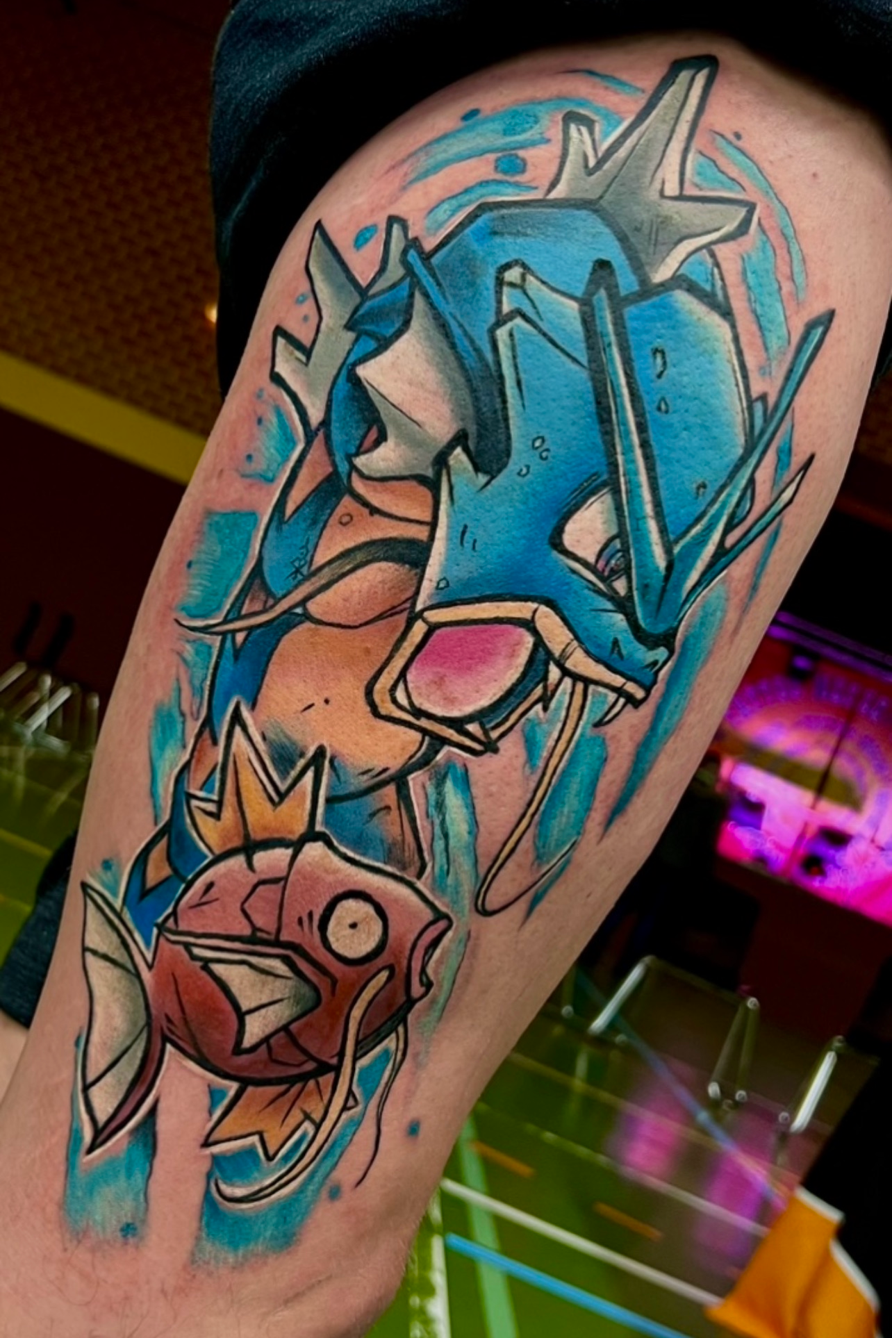 Pokémon Tattoo mit Garados und Karpador auf dem Oberschenkel.