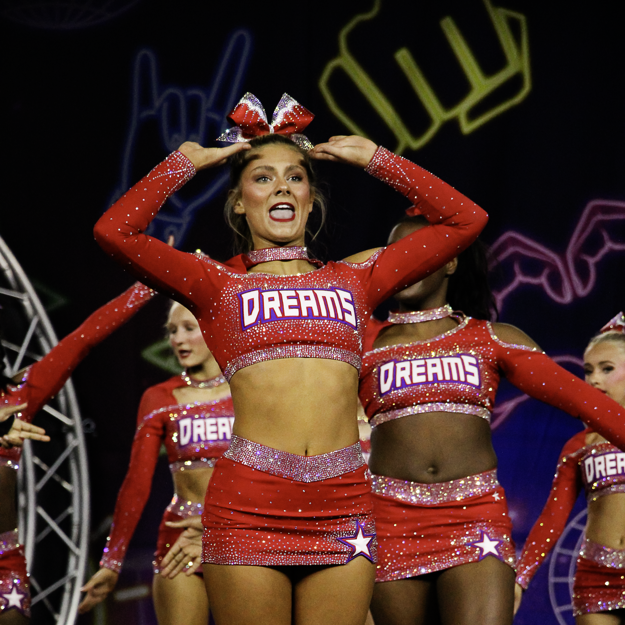 Cheerleaders wearing red glitter costumes with