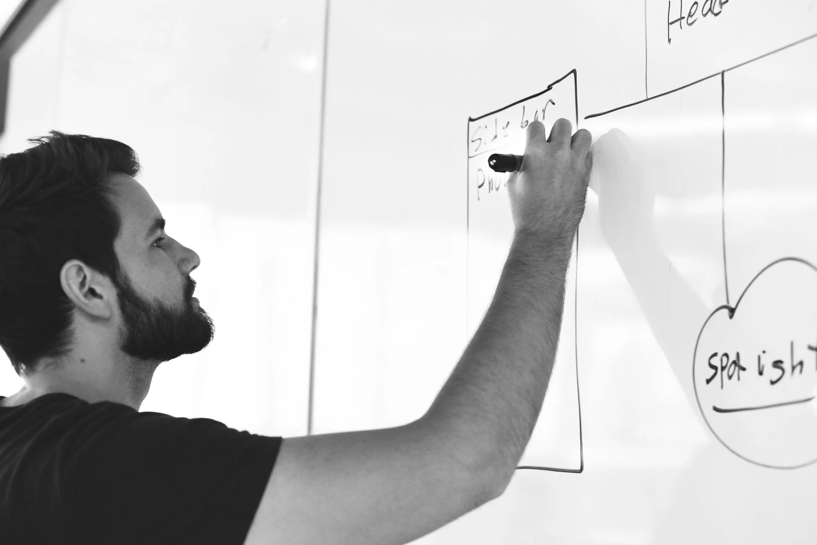 Les Tables Rondes offrent des services professionnels incluant l'accompagnement de réflexions stratégiques et l'animation d'assemblées. L'image l'illustre avec un consultant écrivant sur un tableau blanc avec un marqueur.