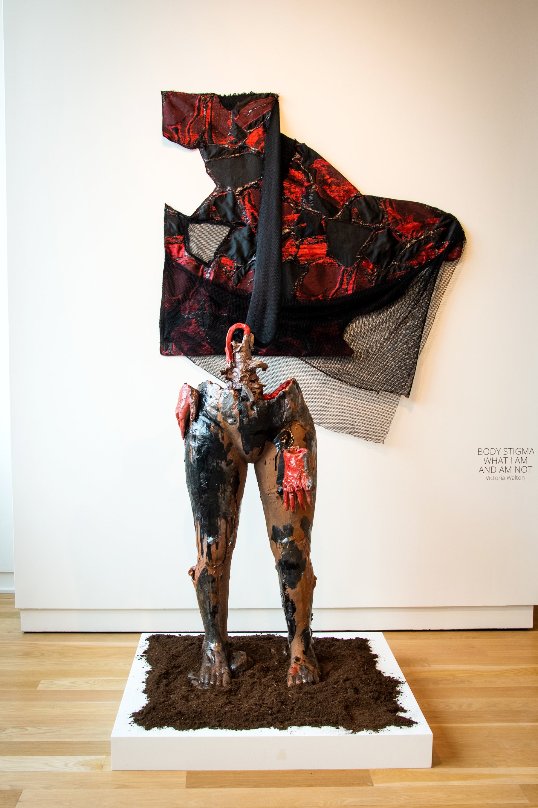 Body Stigma - what I am and am not
Ceramic, silk brocade, netting, spray paint, 2022
H 47” W 18” D 16”

The figure is partial from the feet to mid-torso. Two hands are attached around the waist, displaying different qualities of pain, one through a b