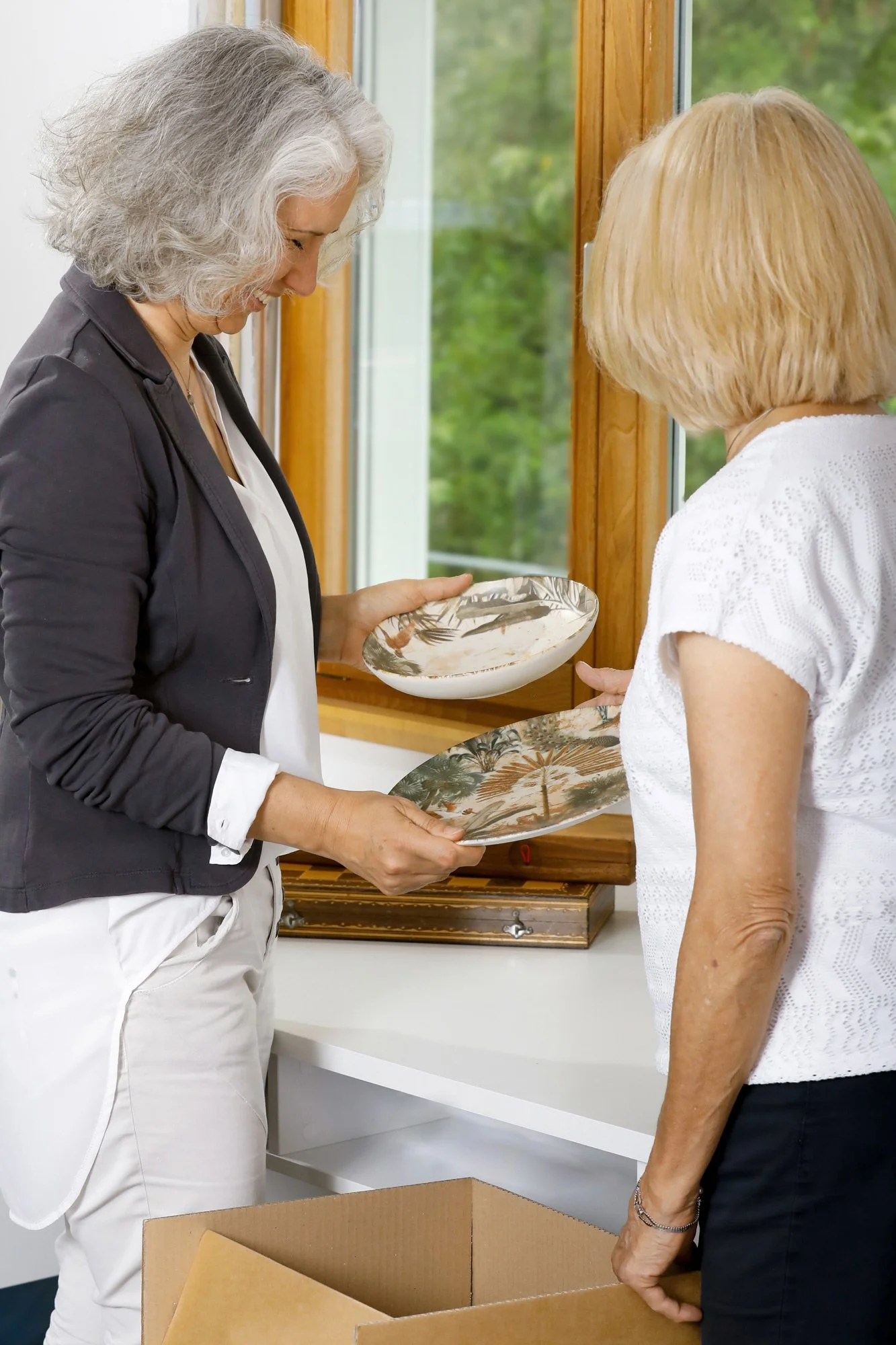 Downsizing-Beraterin Evelyn Mayer bereitet mit Seniorin aus Stuttgart den Umzug vor und verpackt wertvolle Dinge.