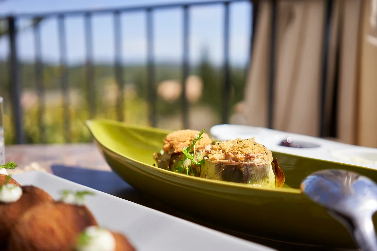 Close-up of baked stuffed eggplant on a green leaf-shaped dish with a blurred background.