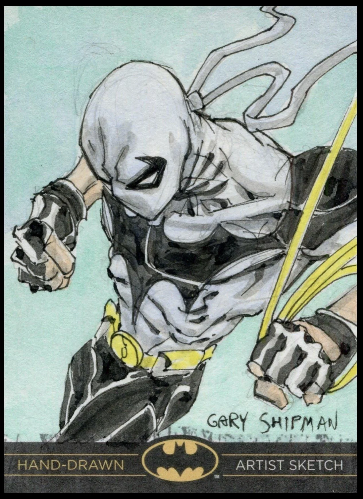 Batman legend sketch card. A hand-drawn illustration of Batman with a cape and cowl, looking down and holding a gadget in one hand. The artwork is signed by Gary Shipman.