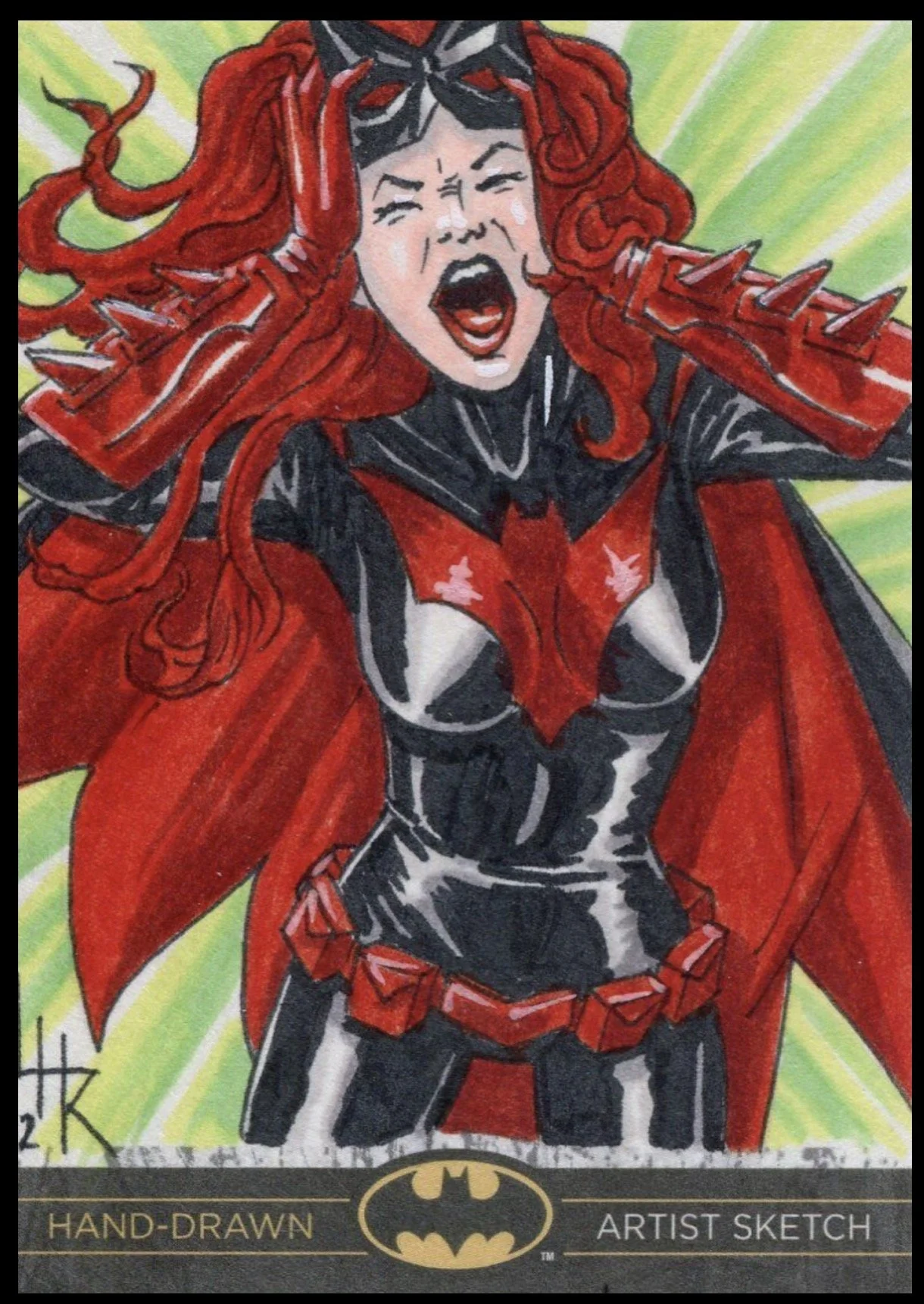Batman legend sketch card. A hand-drawn comic-style illustration of Batwoman with long red hair, wearing a black and red superhero suit with a cape, spiked shoulder pads, and a confident expression, against a green and yellow background.