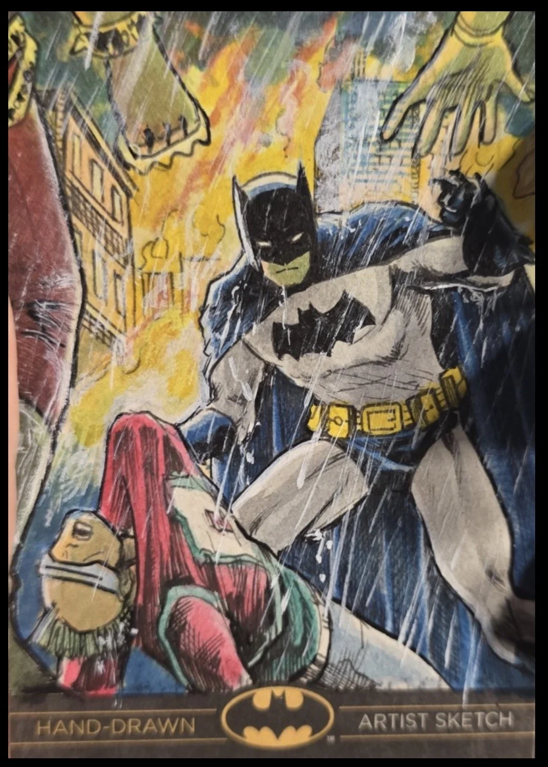 Batman legend sketch card. Hand-drawn illustration of Batman fighting the Joker, with fire and explosions in the background, and Batman holding Robin, who appears injured.