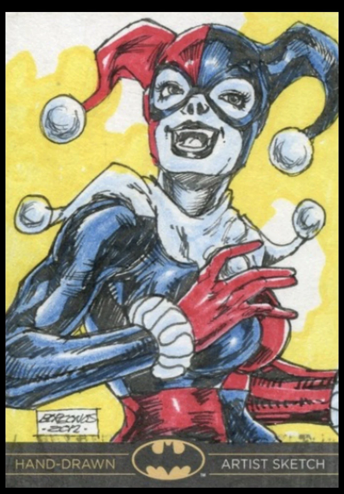 Batman legend sketch card. A hand-drawn illustration of Harley Quinn as a Batman character, wearing a red and blue jester hat with pom-poms, goggles, a black and blue costume, red gloves, and a mischievous expression.