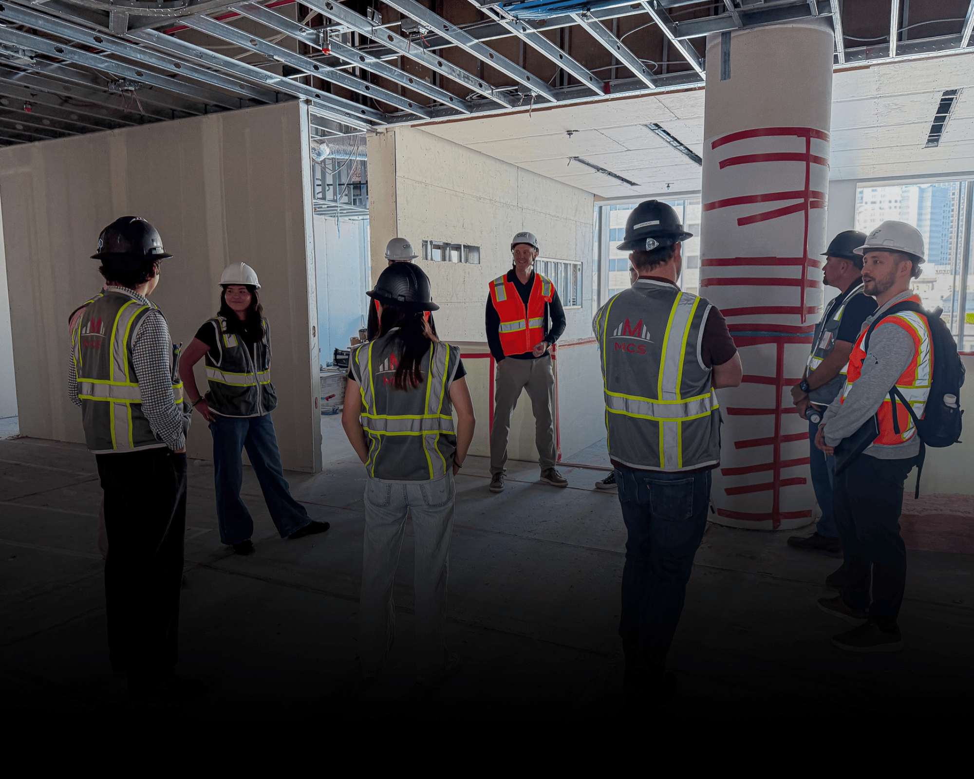 MCS Construction workers and engineers wearing safety helmets and vests on a Silicon Valley job site