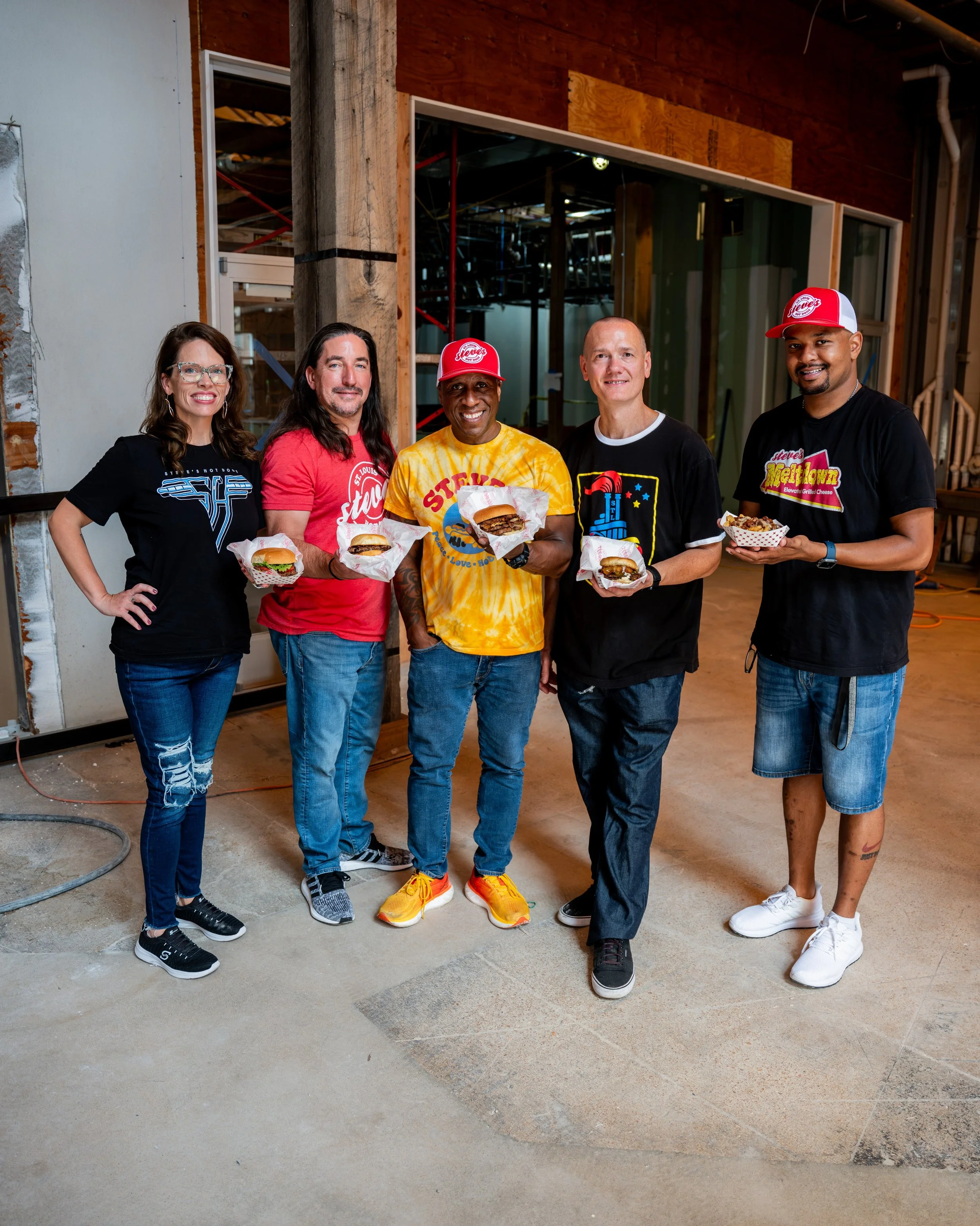 Owners and Leaders of Steve's Smash STL stand in the construction site for Wash Ave Food Hall in St. Louis