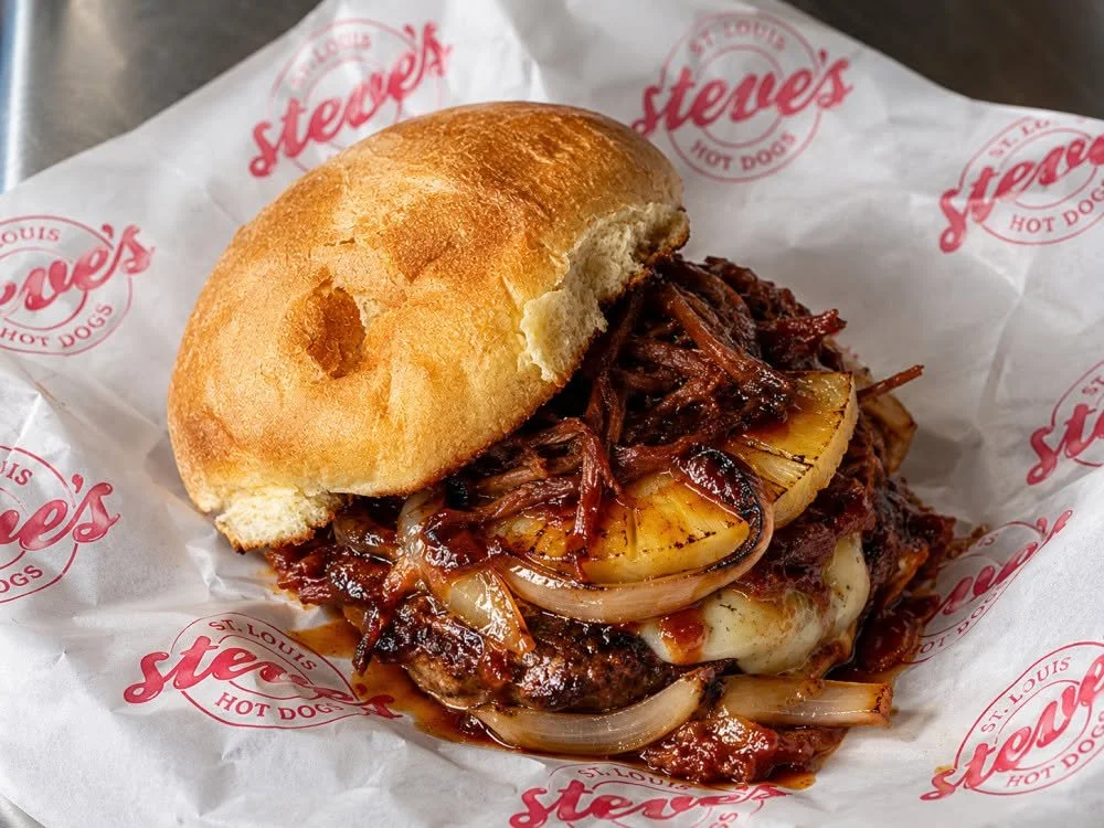 Tropic Thunder Smashburger: A single tri-blend smashburger patty topped with pulled pork, Pepperjack cheese, grilled pineapple, grilled onions and Honey Chipotle BBQ sauce. 