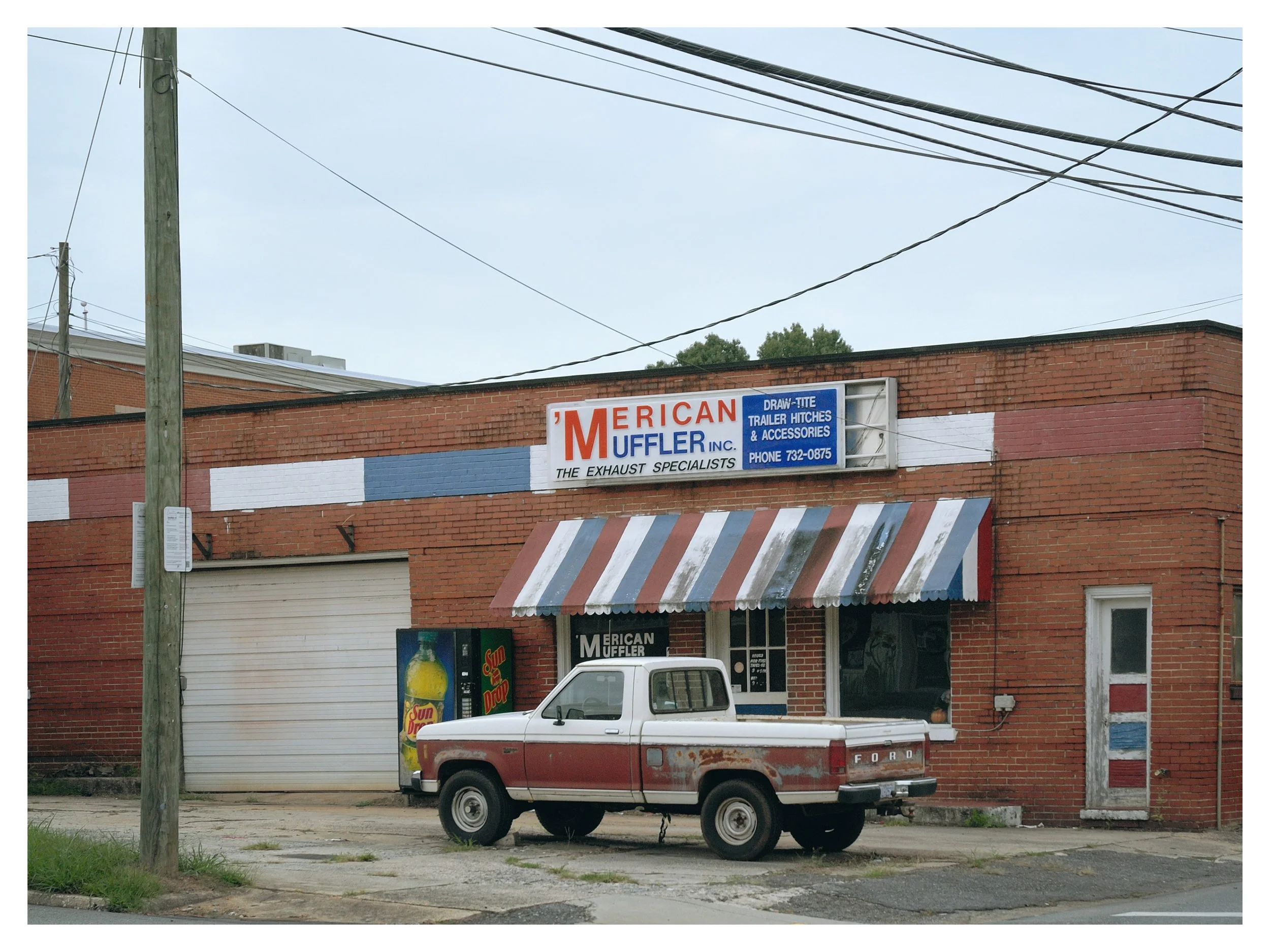 'Merican Muffler, Lincolnton NC.  The colors drew me to this shot as they're so consistent, red, white and blue, even on the truck. 