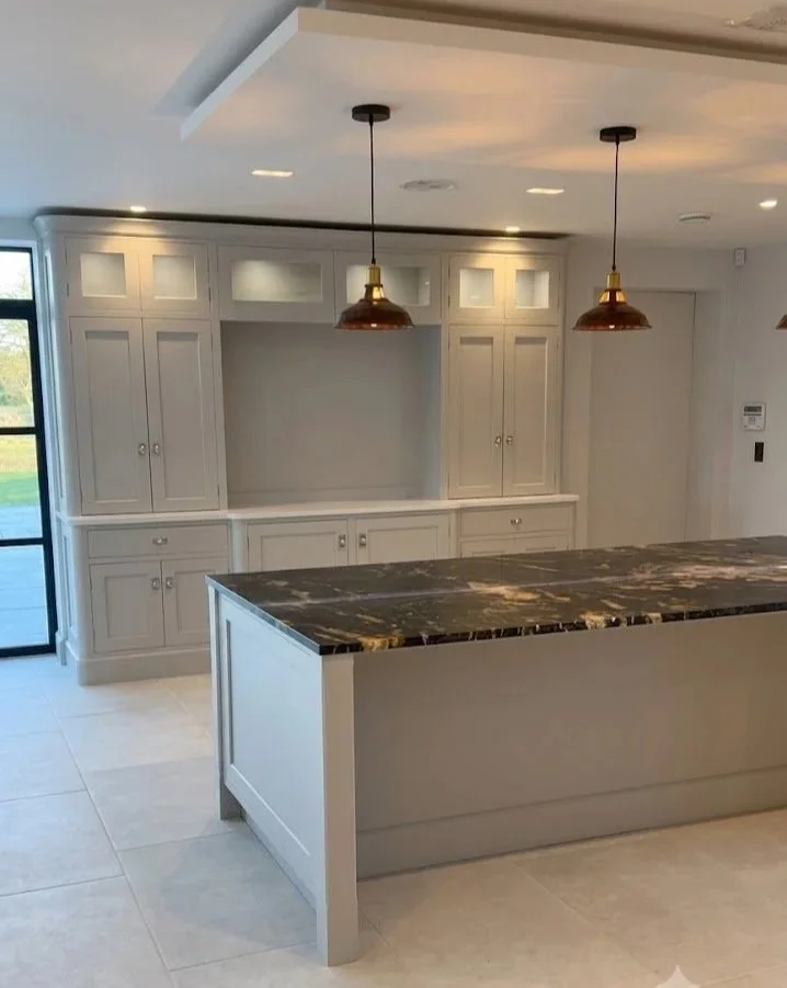 Bespoke in-frame Shaker kitchen featuring a dark veined quartzite feature island, brass pendant lights, and integrated dresser by Ken Pope Custom Joinery in Welwyn Hertfordshire