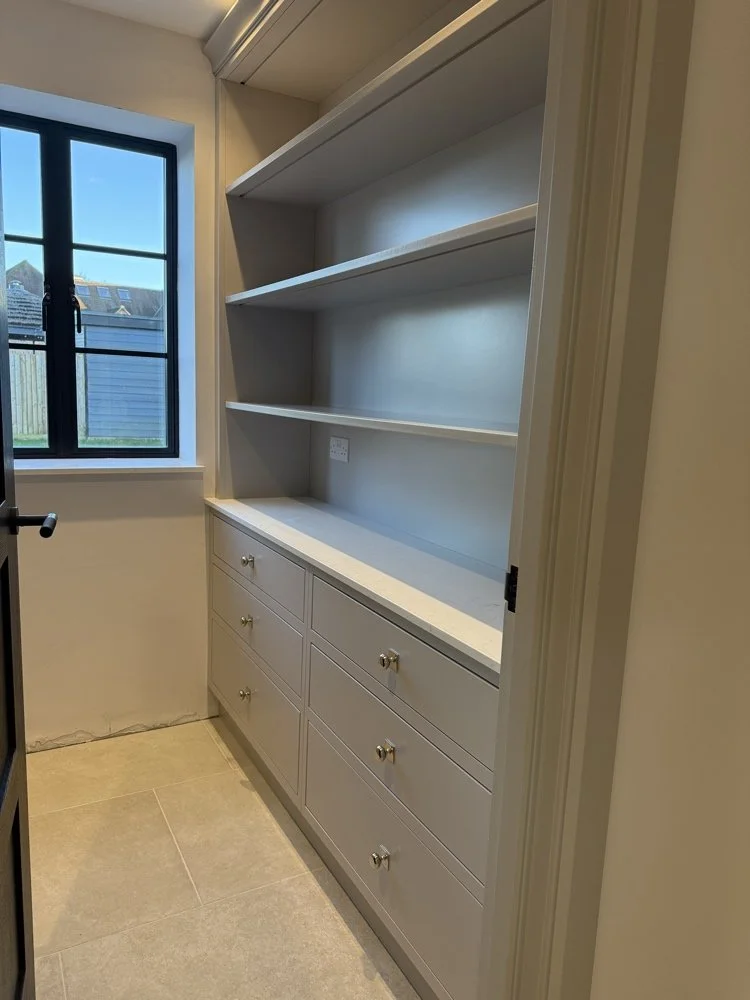 Bespoke in-frame pantry storage run with painted drawer banks, polished brass hardware, quartz worktop, and open upper shelving in Welwyn Hertfordshire by Ken Pope Custom Joinery