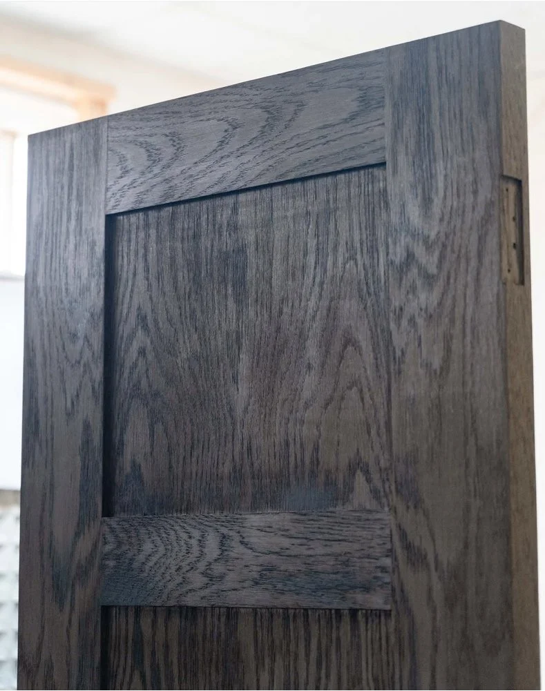 Close-up macro detail of crown-cut ebonized European oak wood grain on a custom four-panel internal door crafted by Ken Pope Custom Joinery