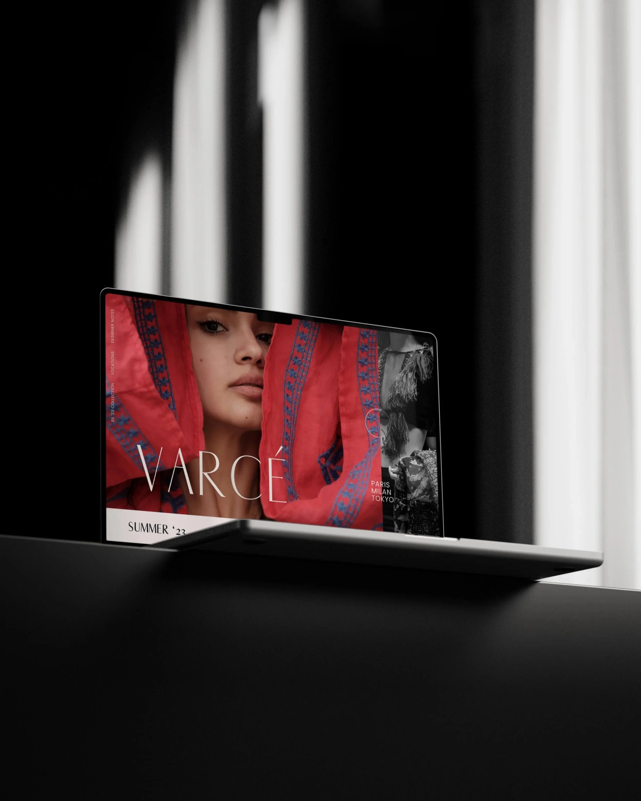 The image shows a smartphone displaying a fashion magazine cover with a woman in a red and blue patterned jacket. The background has black and white blurred curtains or shadows.