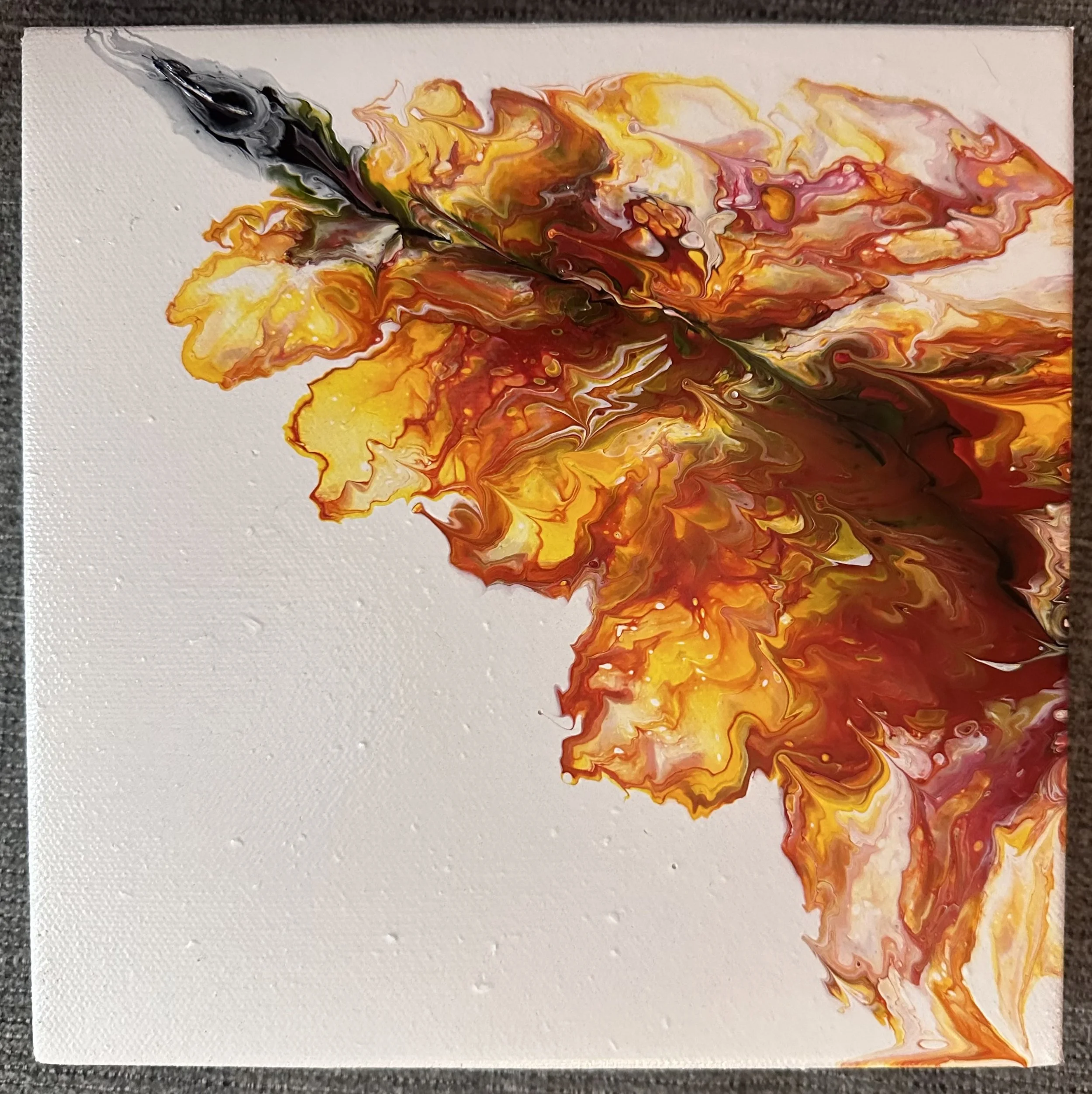 Abstract painting with swirls of black, yellow, orange, pink, and red on a white canvas.