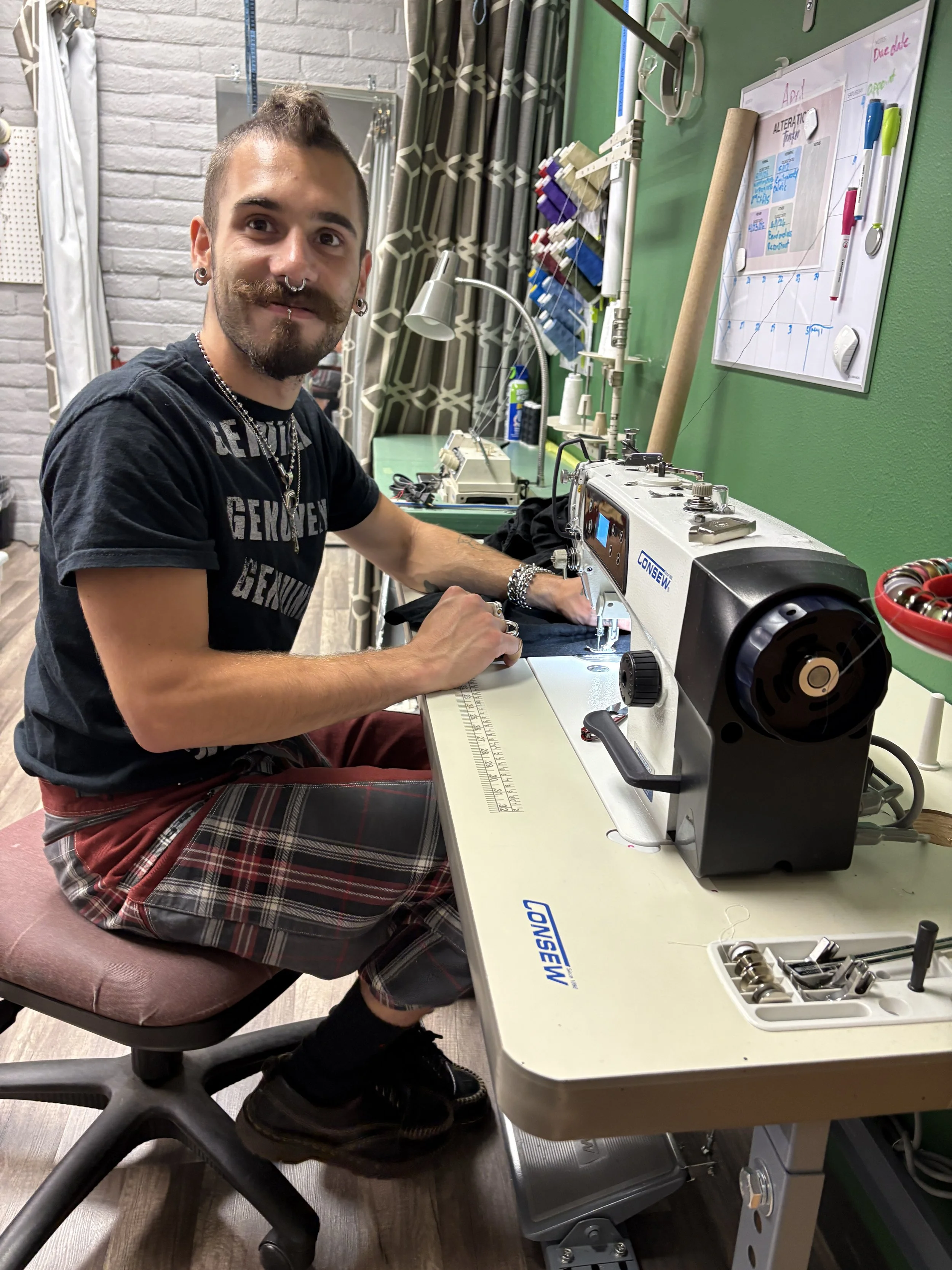 Jake Wright, Viking's alterationist, working at an industrial sewing machine on a clothing alteration