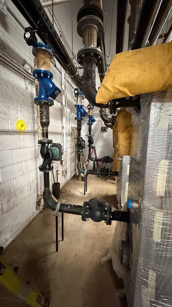 View of plumbing pipes and valves in an industrial setting.