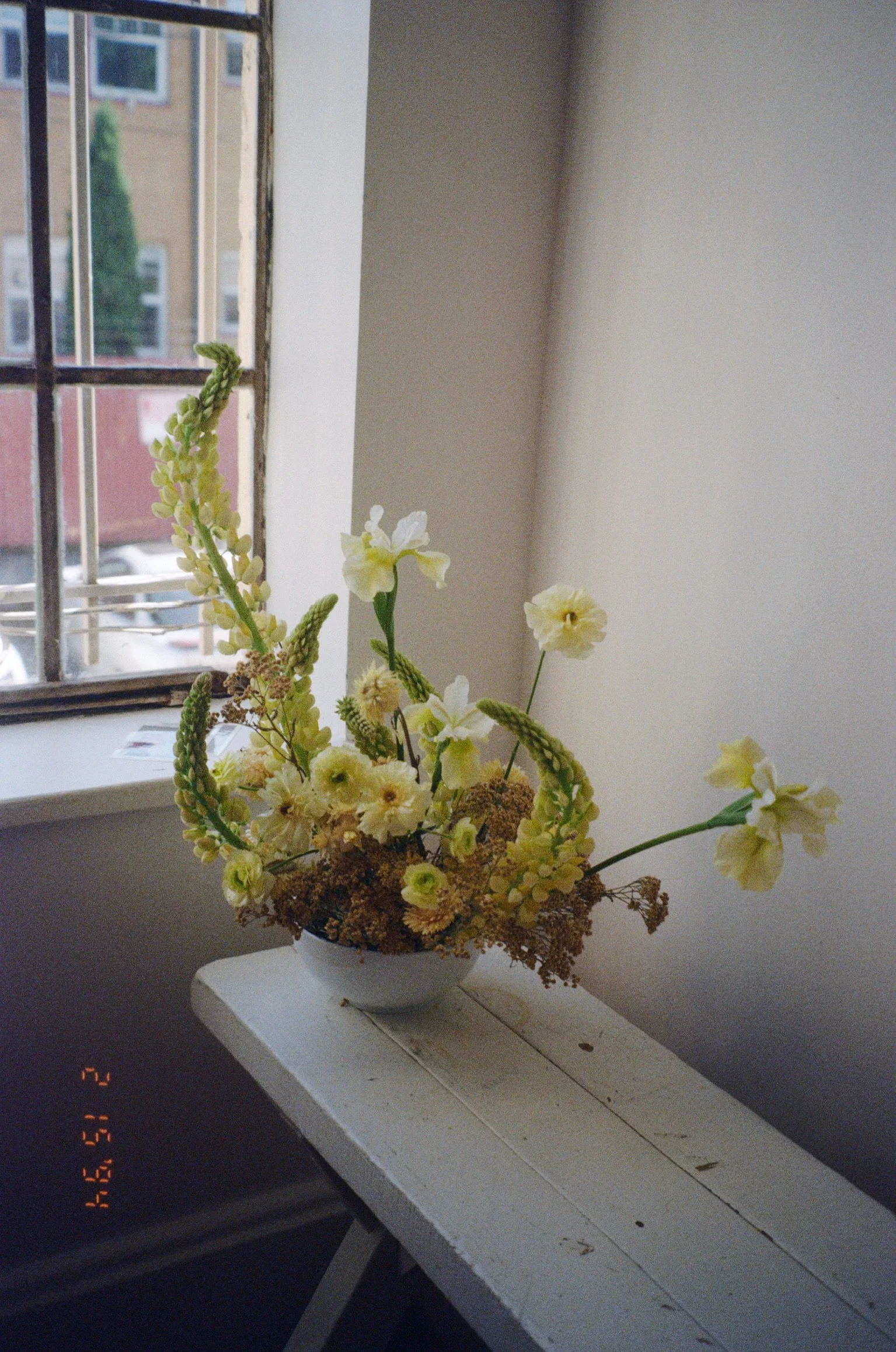 Flowers on a white bench near a window at Hedon HQ in Portland, Oregon.