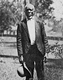 man in black and white picture holding a hat
