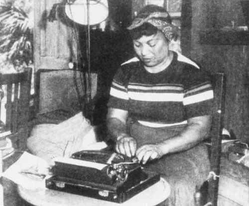 woman wearing a handkerchief typing on a typewriter