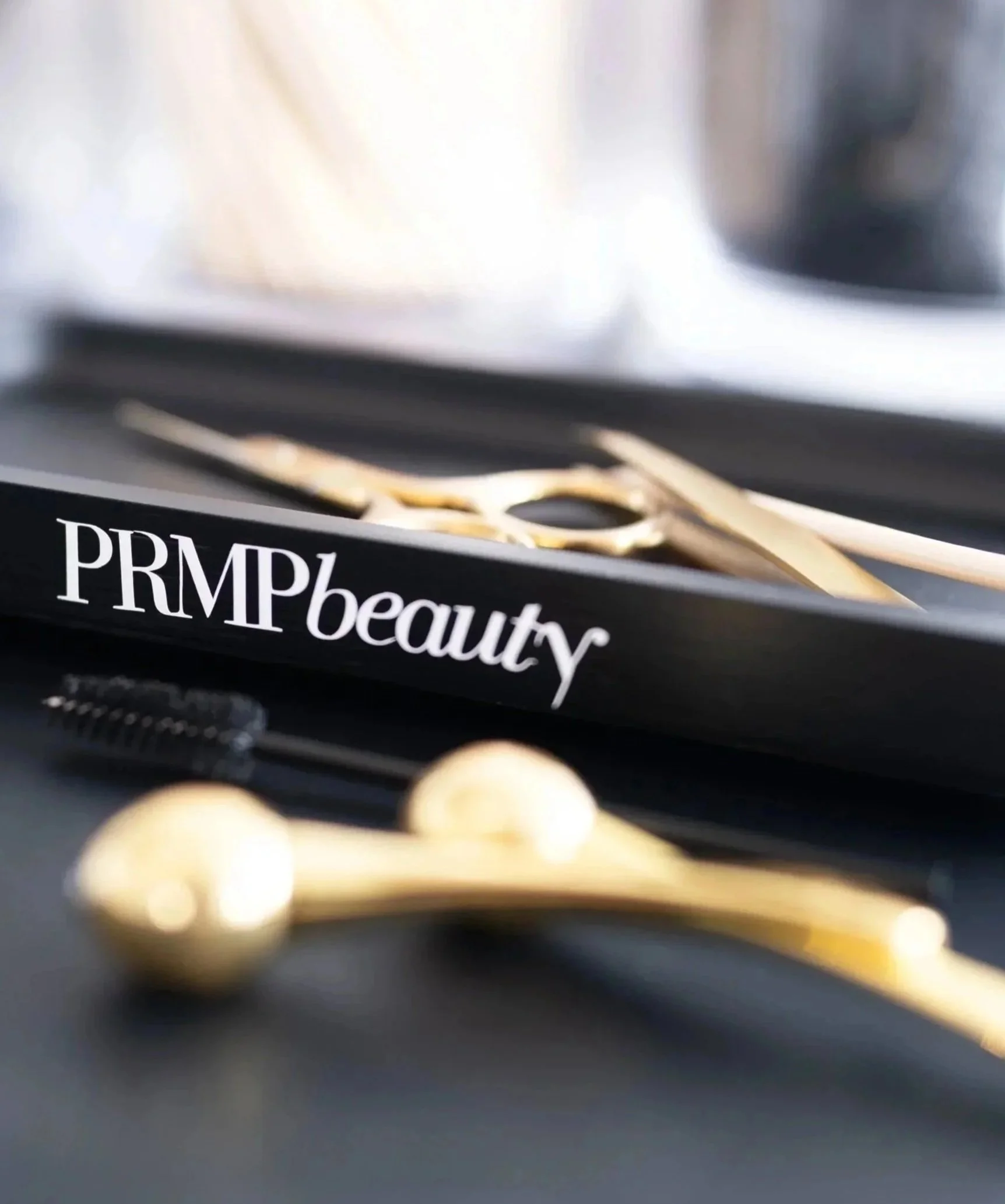 Close-up of a Prada Beauty product box with gold-colored decorative elements and the word 'PRADA' visible.