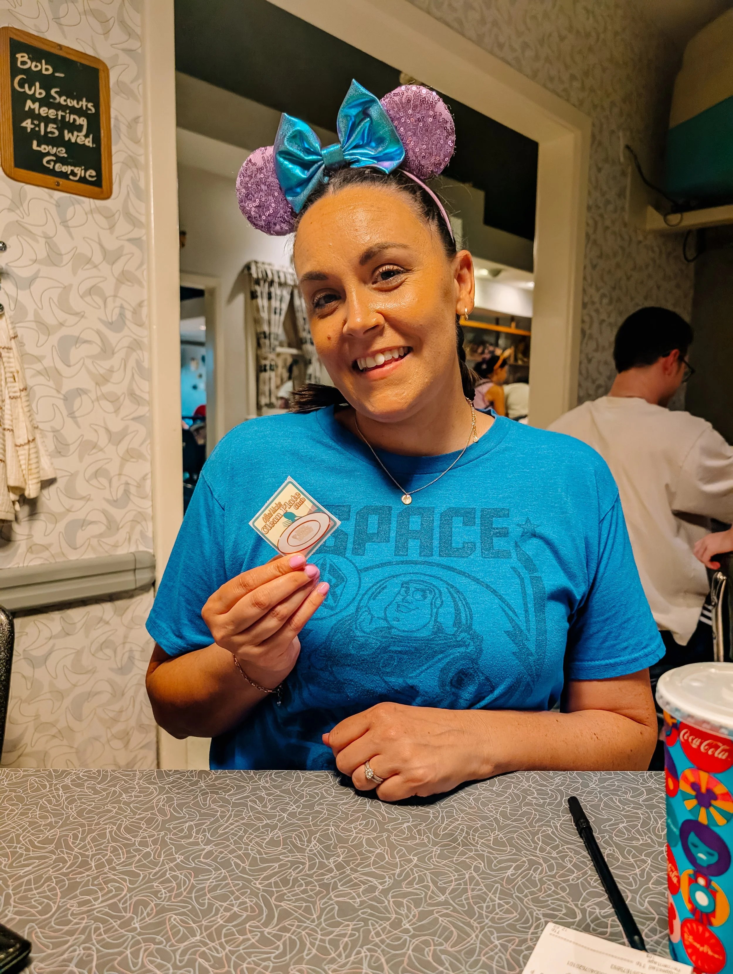 Travel advisor holding a sticker while waiting for a table-service dining reservation.