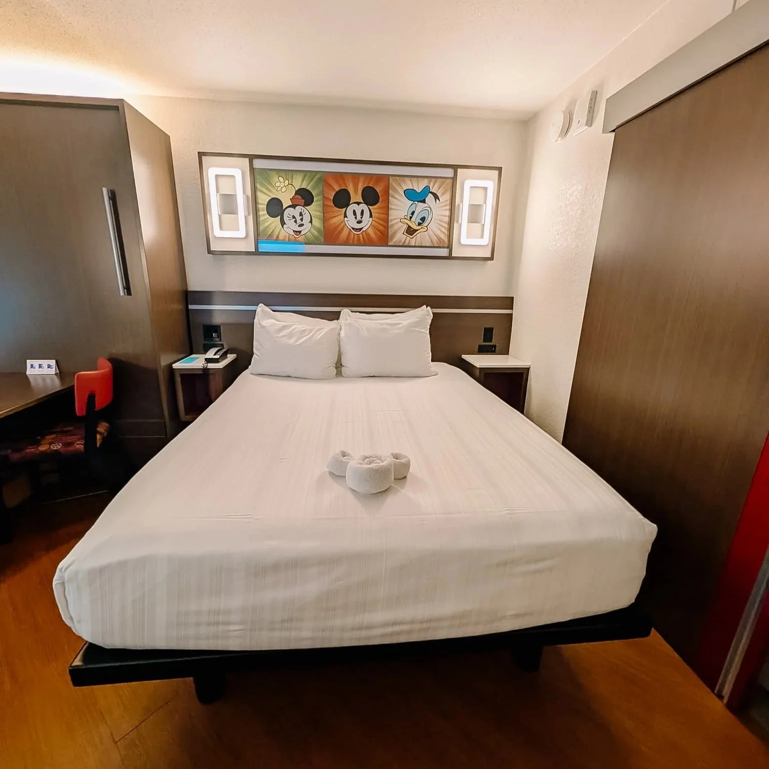 Bed at Disney Allstar Resort with a towel folded into the shape of micey mousek