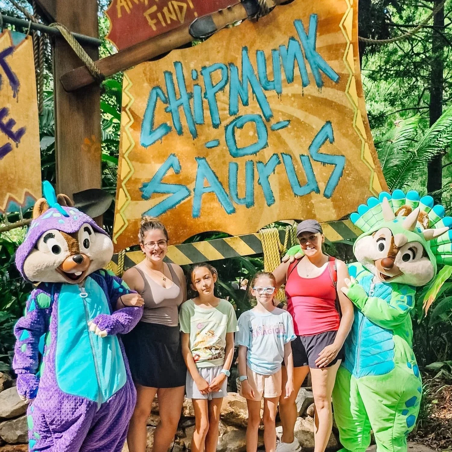 Adults and kids posing with Chip and Dale dressed as dinosaurs at Disney's Animal Kingdom