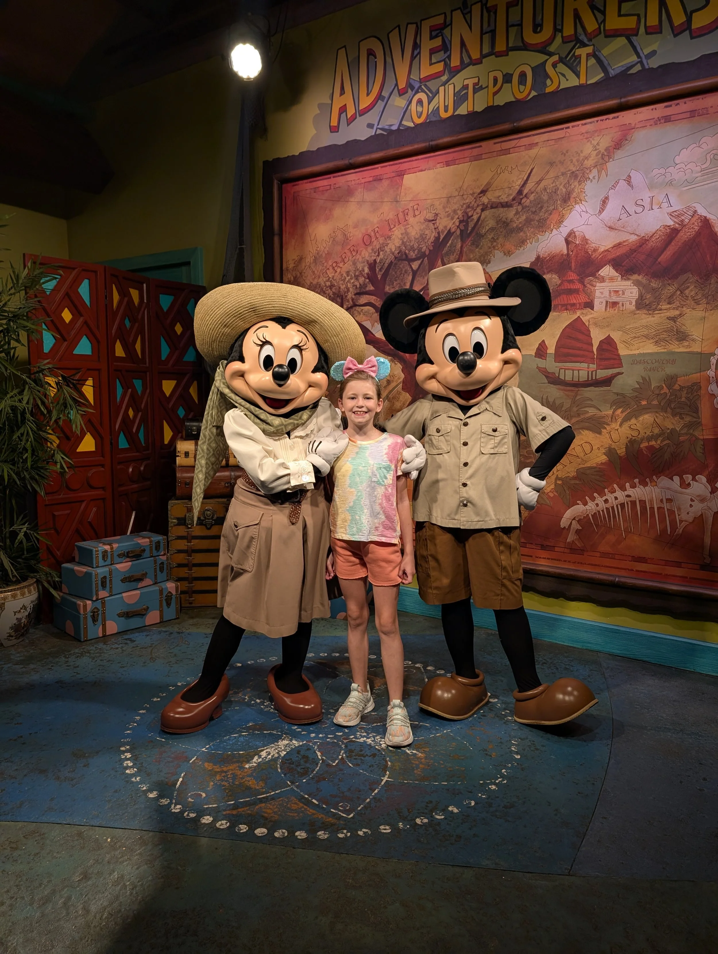 Child posing with Adventure Mickey and Adventure Minnie during a Disney World character meet and greet at Animal Kingdom.