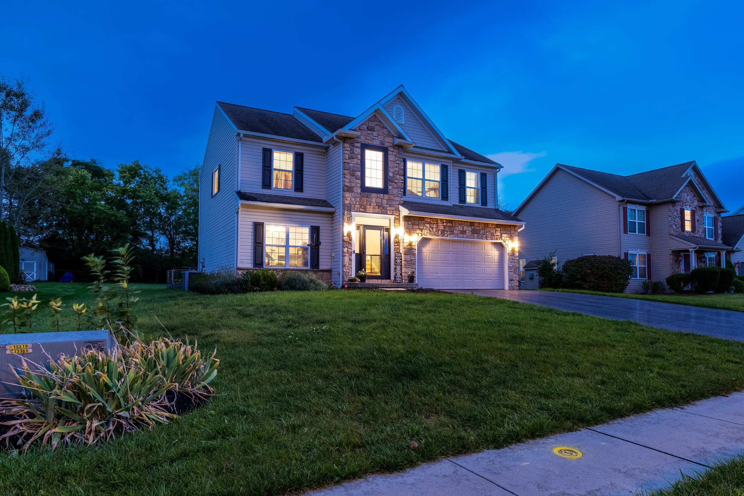 A two-story house illuminated at dusk twilight