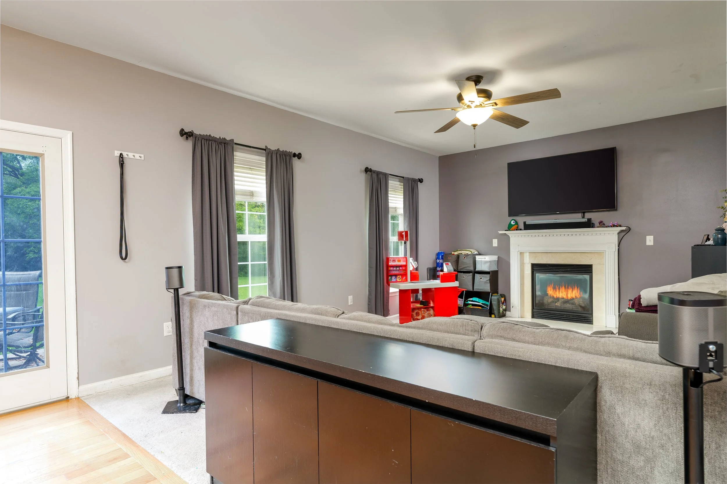 Spacious living room with fireplace TV mount and sliding door access flambient interior real estate photography Carlisle PA