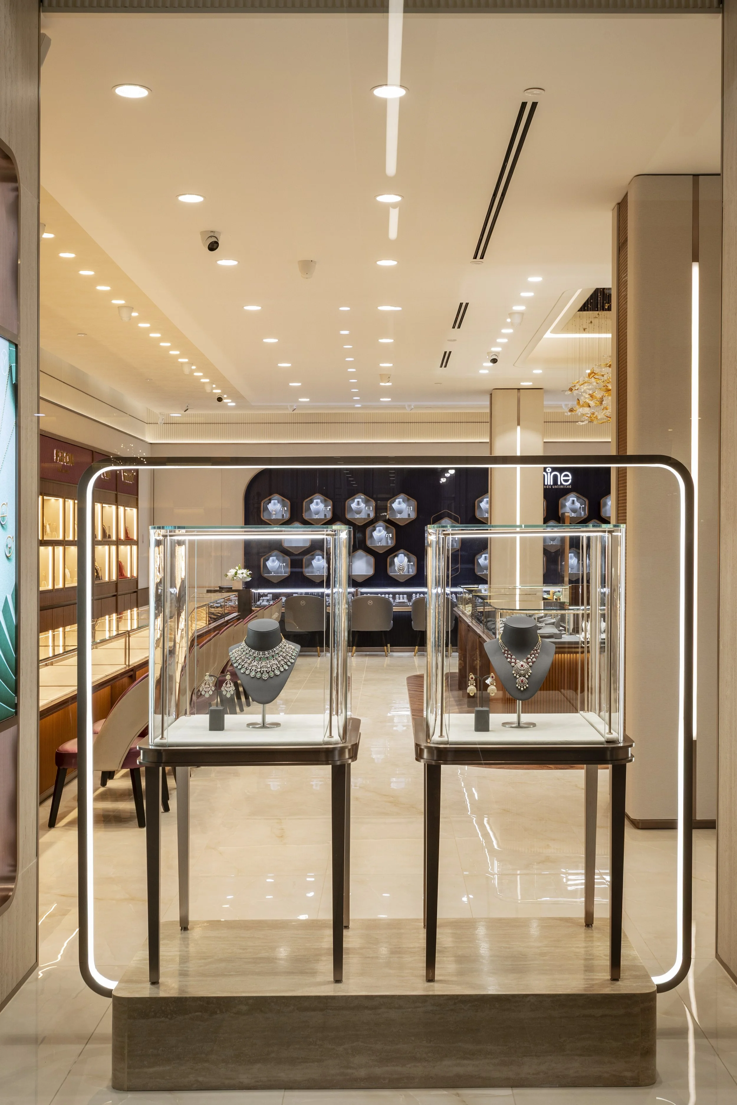 Jewelry display stand with necklaces and earrings inside a luxury jewelry store.