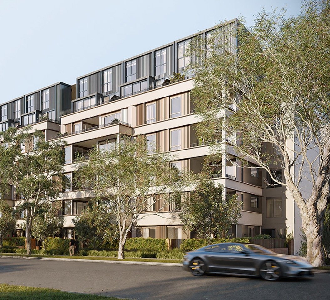 Modern multi-story apartment building with balconies, surrounded by trees, with a black sports car driving on the street in front.