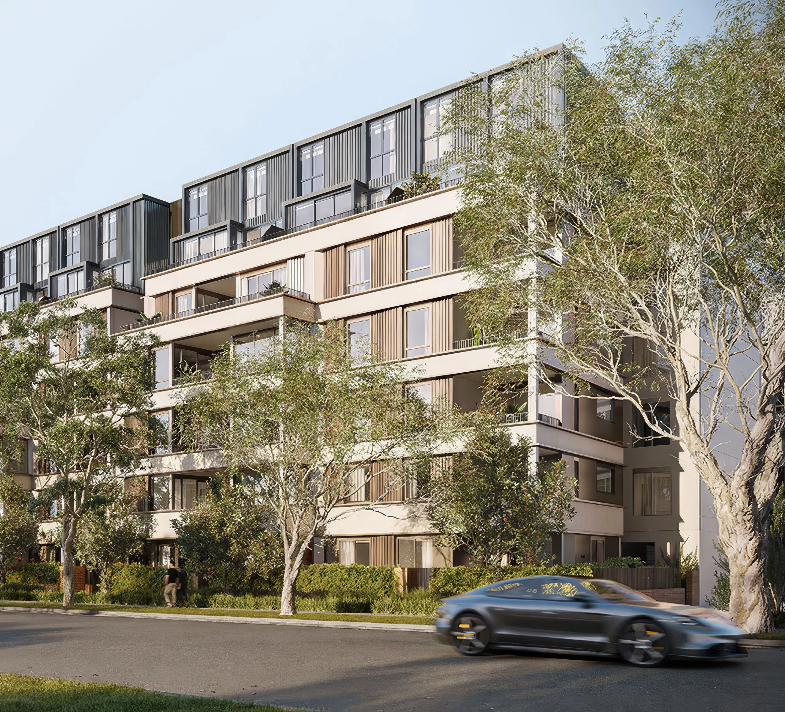 Modern multi-story residential building with large windows, balconies, and vertical siding, surrounded by trees and a street with a moving black car.