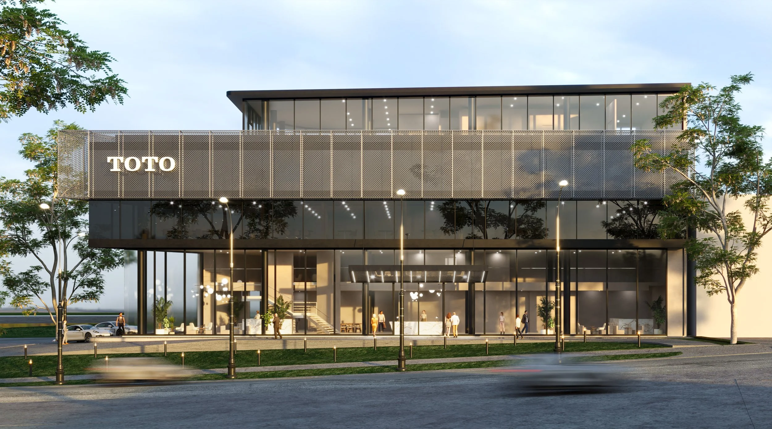 A modern office building with glass windows and the TOTO logo on the front, surrounded by trees and streetlights with people and cars nearby.