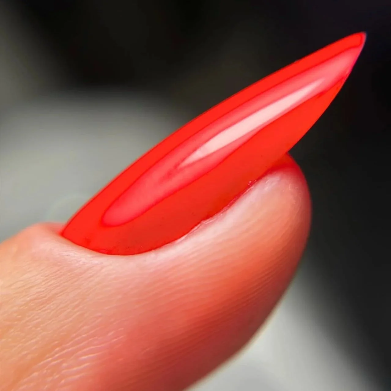 Close-up of a person's fingernail with a red nail tip.
