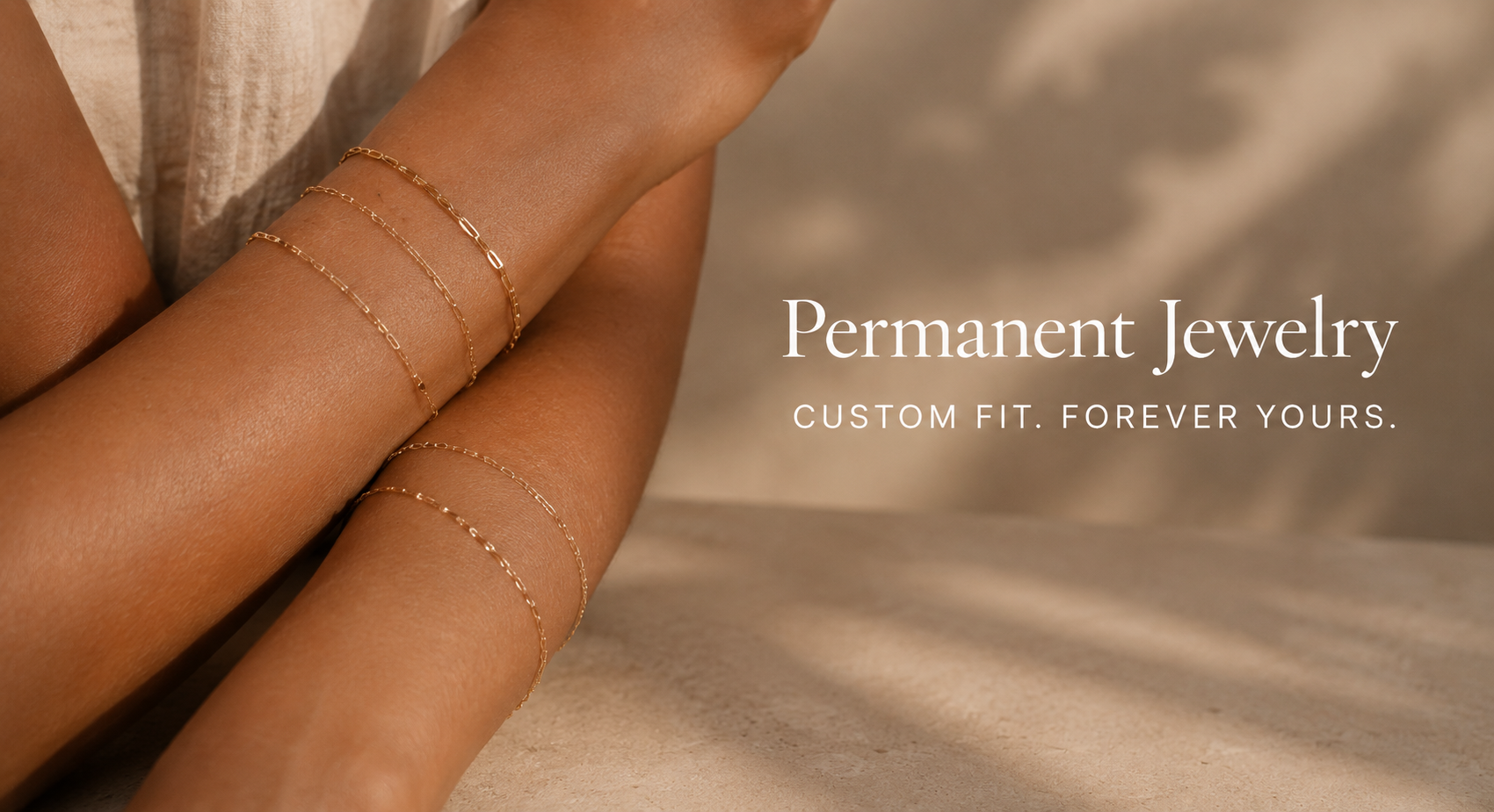 Close-up of a woman's arm wearing multiple delicate gold chain bracelets, with text saying 'Permanent Jewelry, Custom fit. Forever yours.'