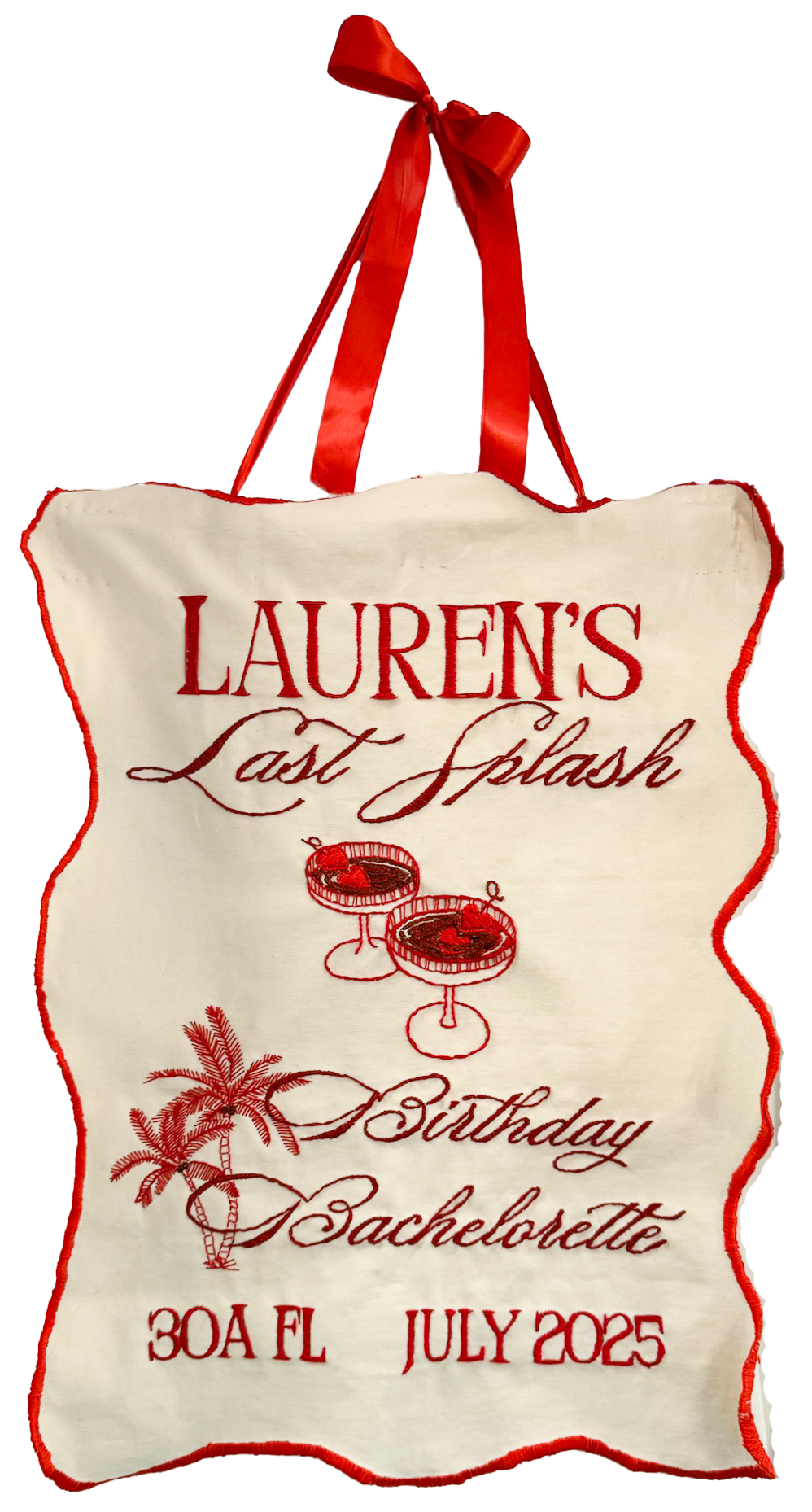 A white fabric banner with red embroidery reading "Lauren's Last Splash" and "Birthday Bachelorette," decorated with a drawing of two drinks, a palm tree, and the date "30A FL JULY 2025," hanging from a red ribbon.