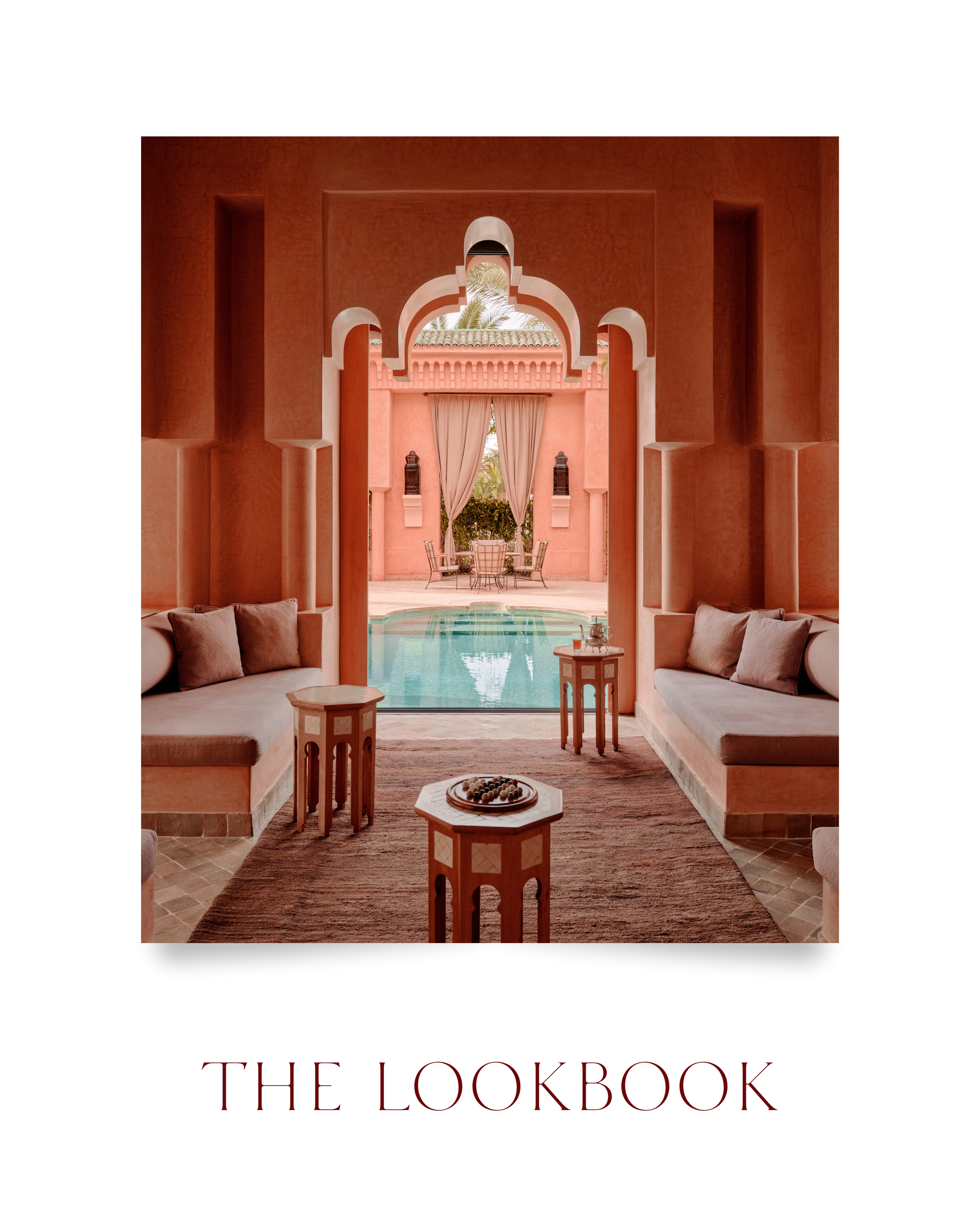 A view through an arched doorway shows a pool, outdoor seating, and beige curtains on a pink building with palm trees in the background.