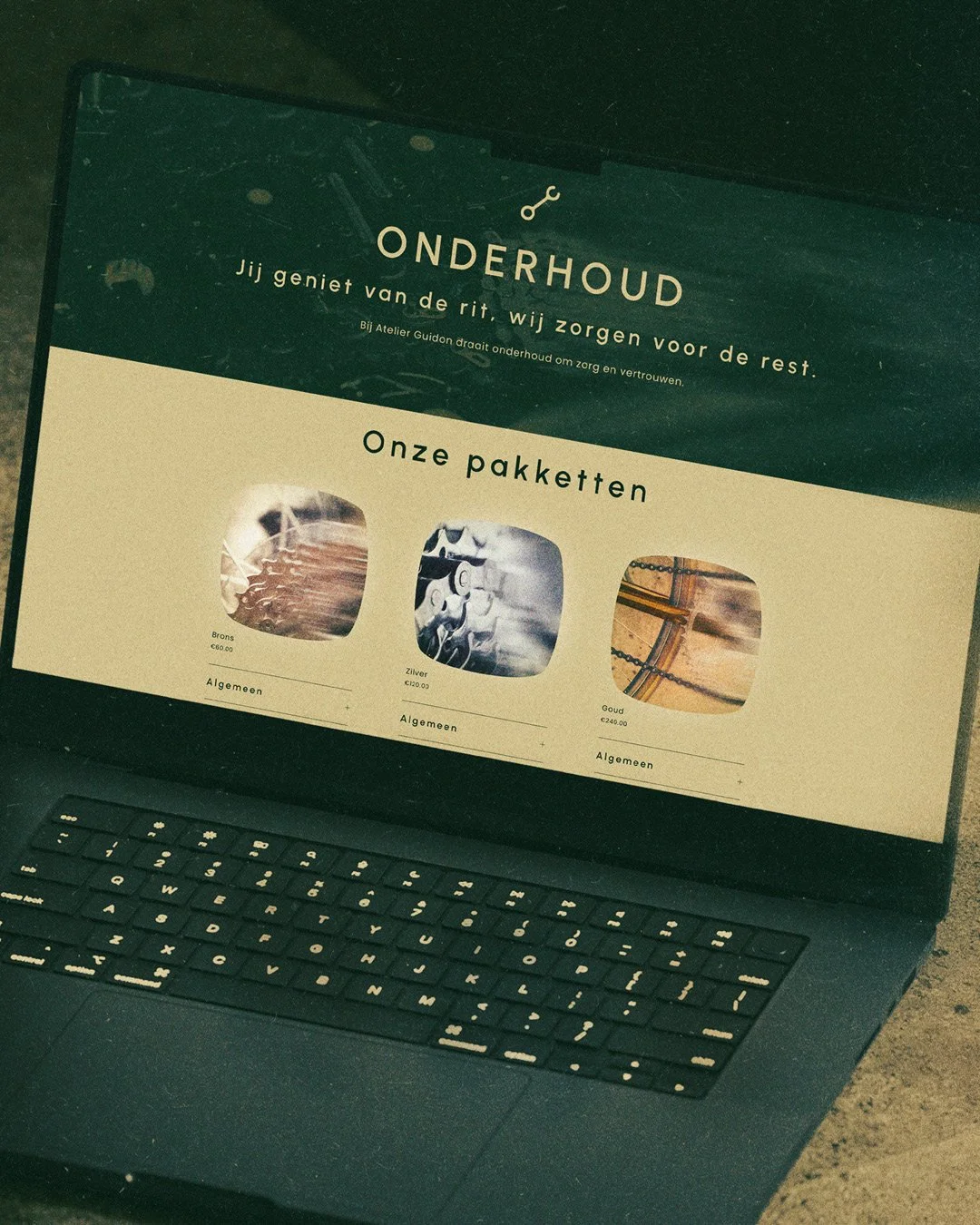 Laptop screen displaying a website about maintenance packages with three options: bronze, silver, and gold. Each package shows a different image and price.